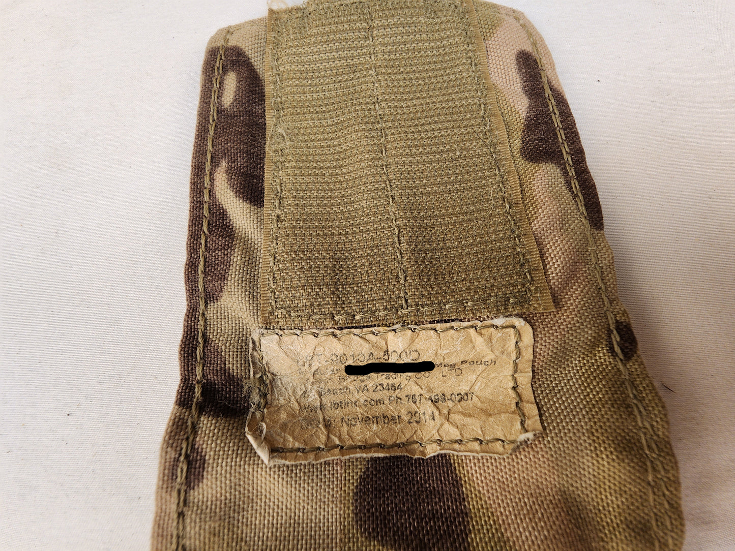 Camouflage pouch with a label on a white background