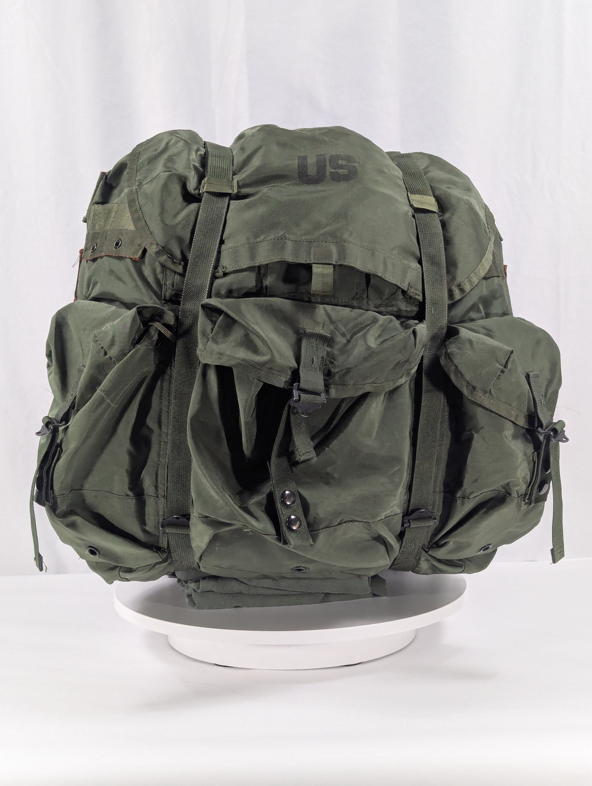 Green military-style backpack on a white background