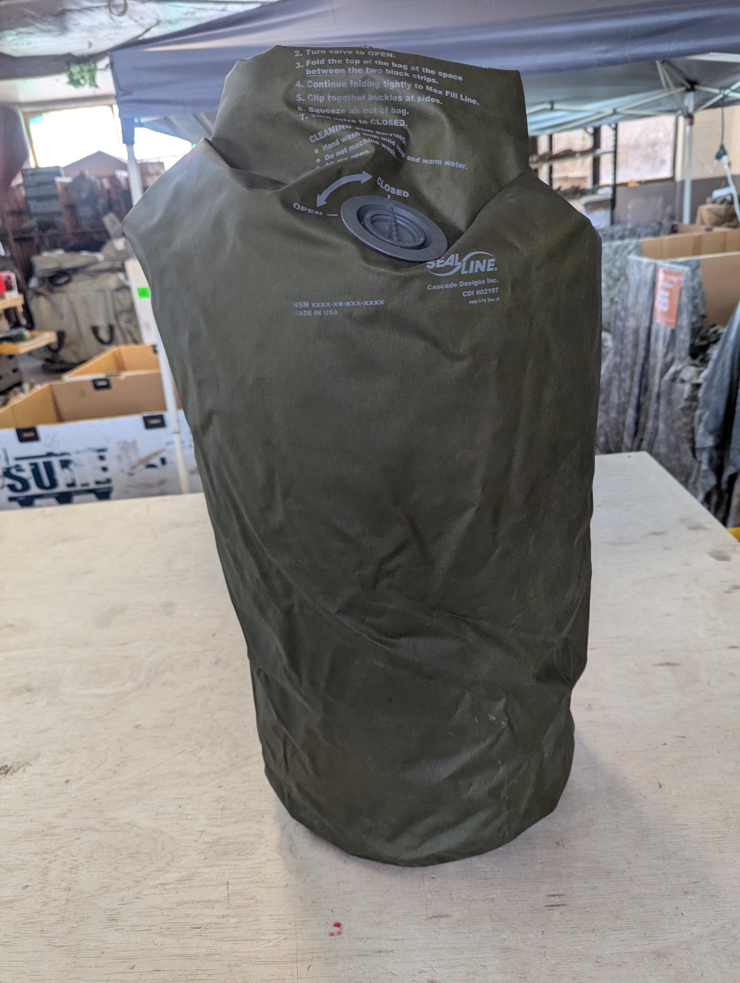 Green dry bag with a brand logo on a light-colored surface