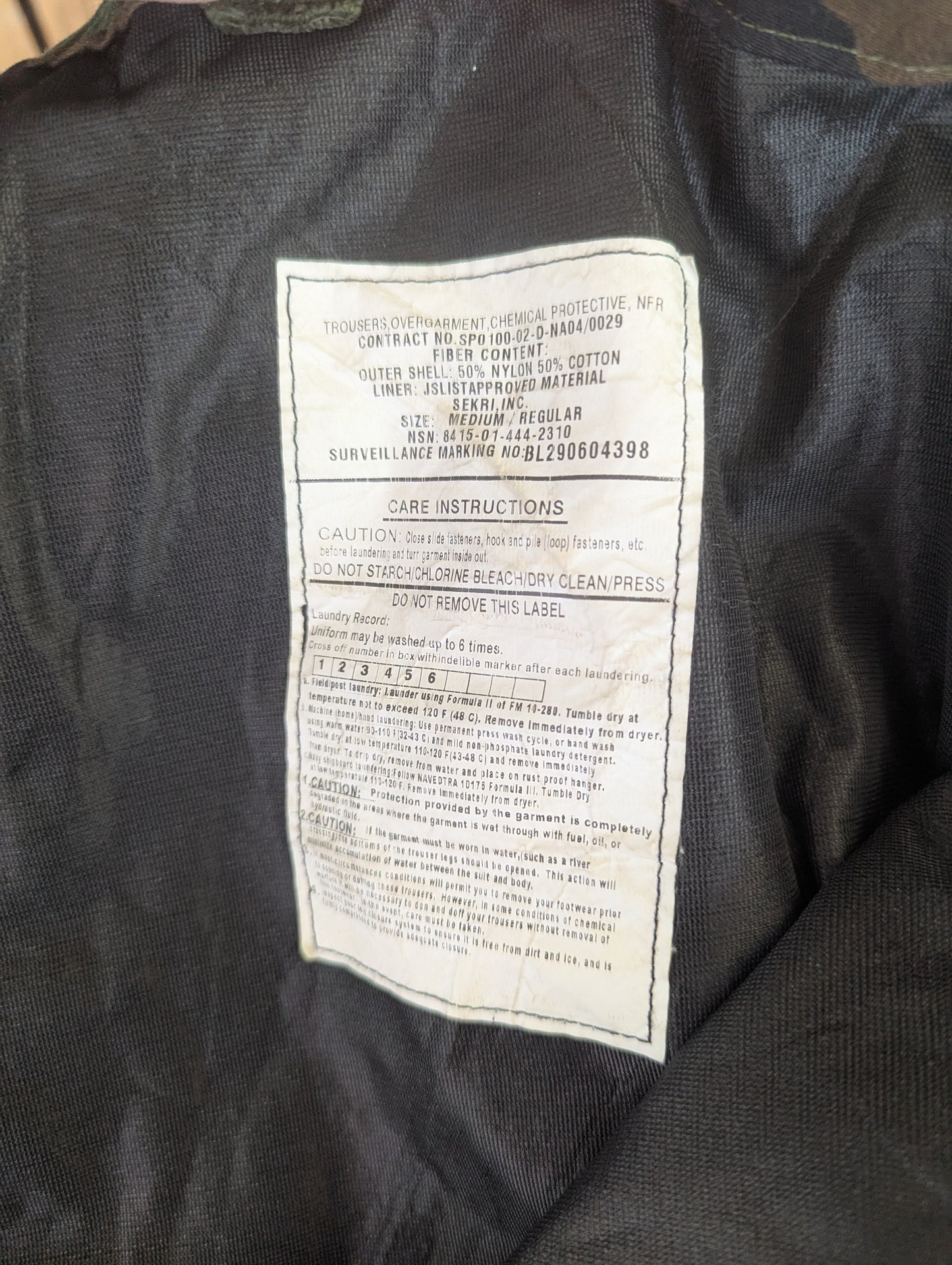 Care label on a black jacket with text and symbols.