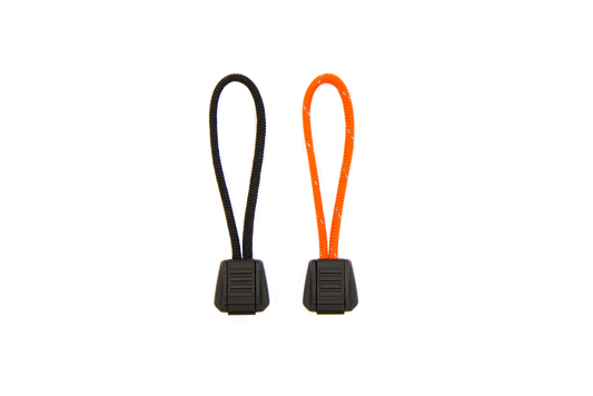 Two multicolored zipper pulls with flammable cores, one orange and one yellow, designed for use as emergency tinders.