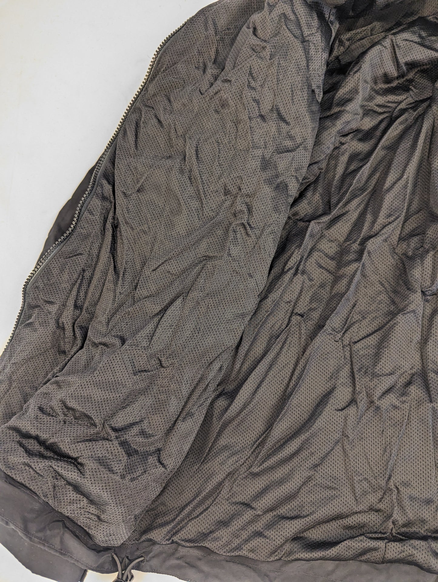 A close-up detail shot of the interior of the U.S. Army Physical Training (PT) jacket, displaying the black breathable mesh lining and fabric texture.