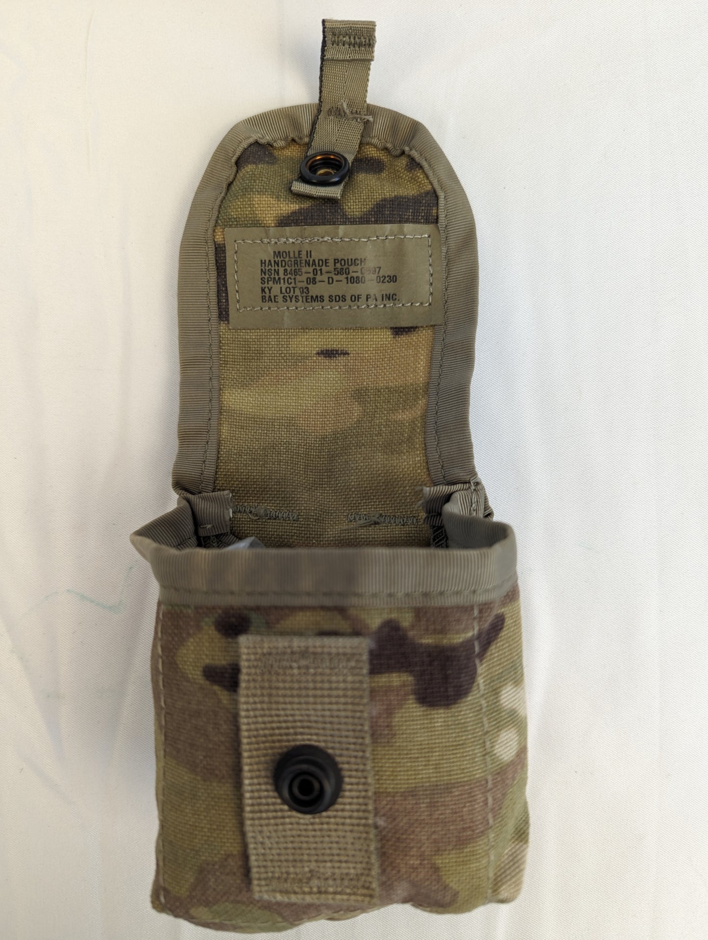A single U.S. Military Surplus hand grenade pouch in OCP/Multicam camouflage, shown with the flap open to reveal the empty interior and the military issue tag sewn onto the flap.