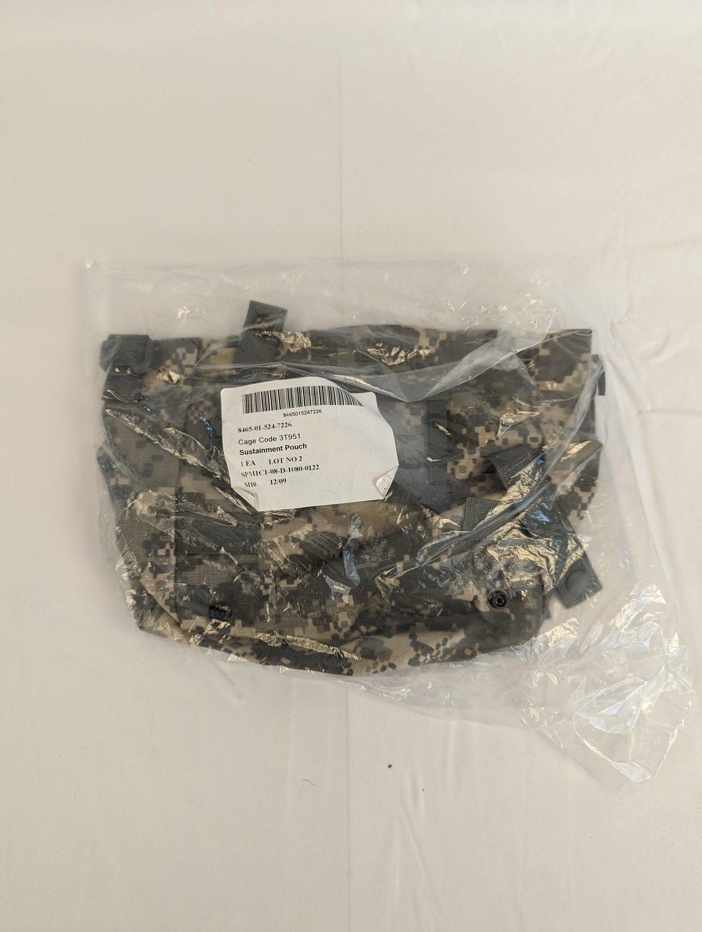 A new U.S. Military Surplus Sustainment Pouch in ACU digital camouflage, sealed inside clear plastic packaging, featuring the official issue label with 'MOLLE II' and NSN markings.