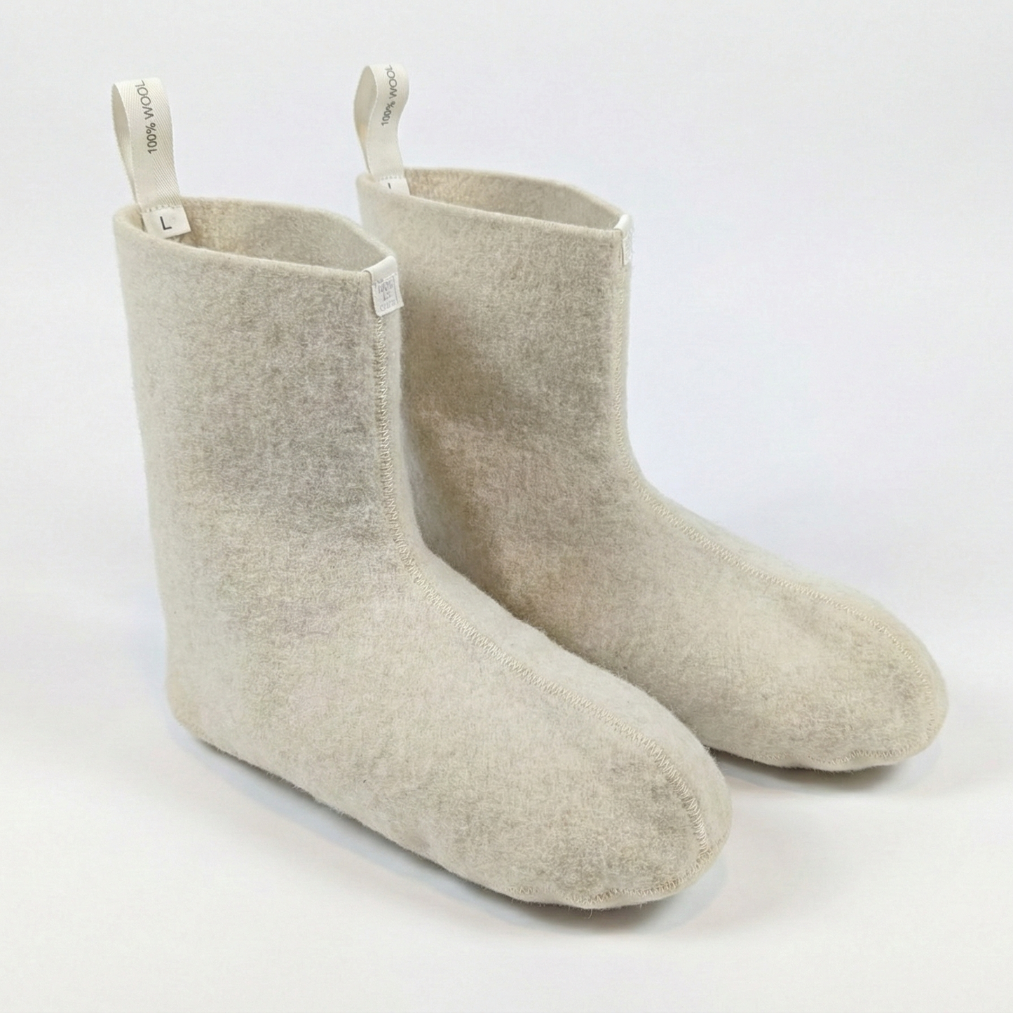 Pair of beige socks with white tags on a white background