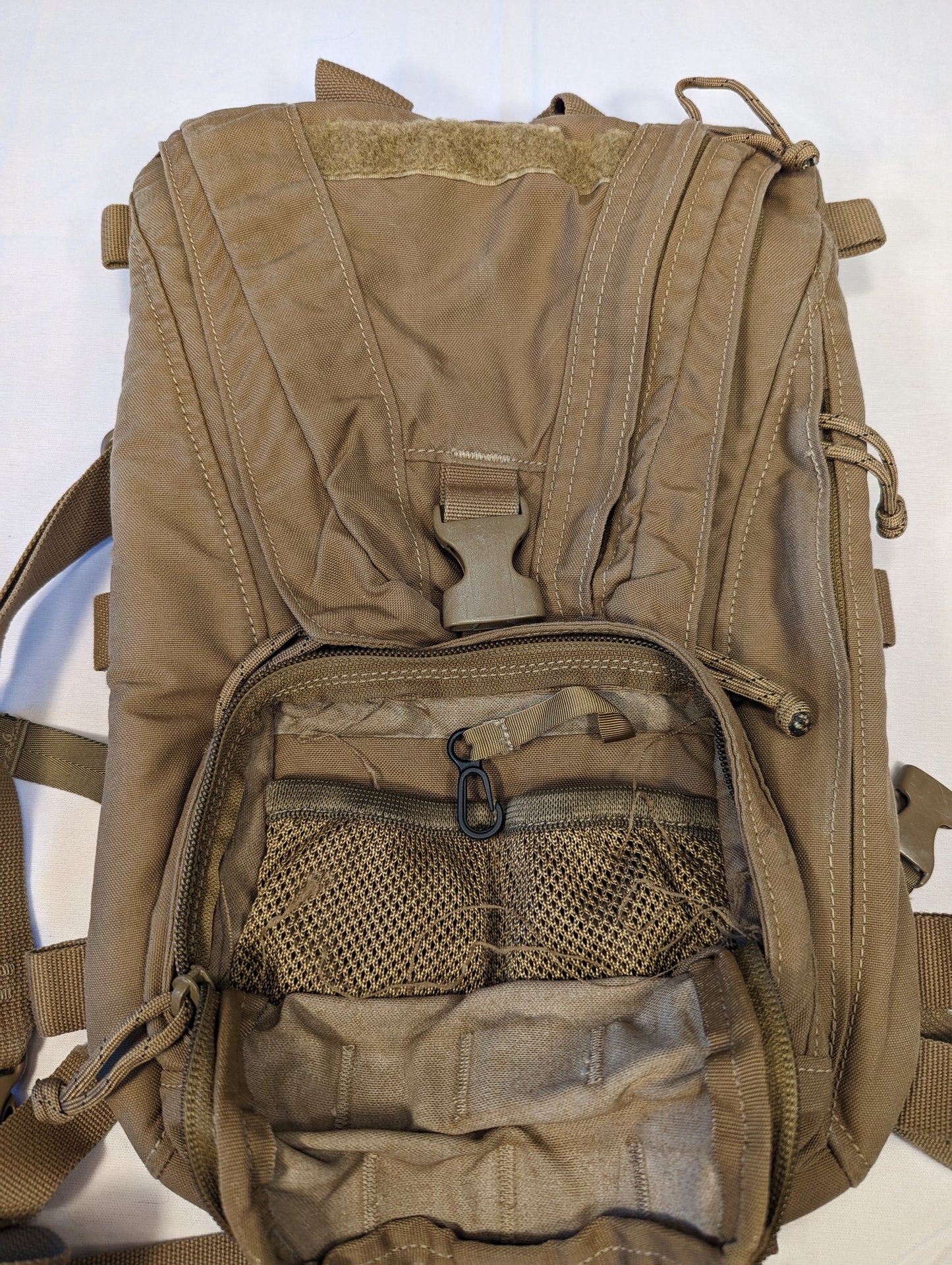 Tan tactical backpack on a white background