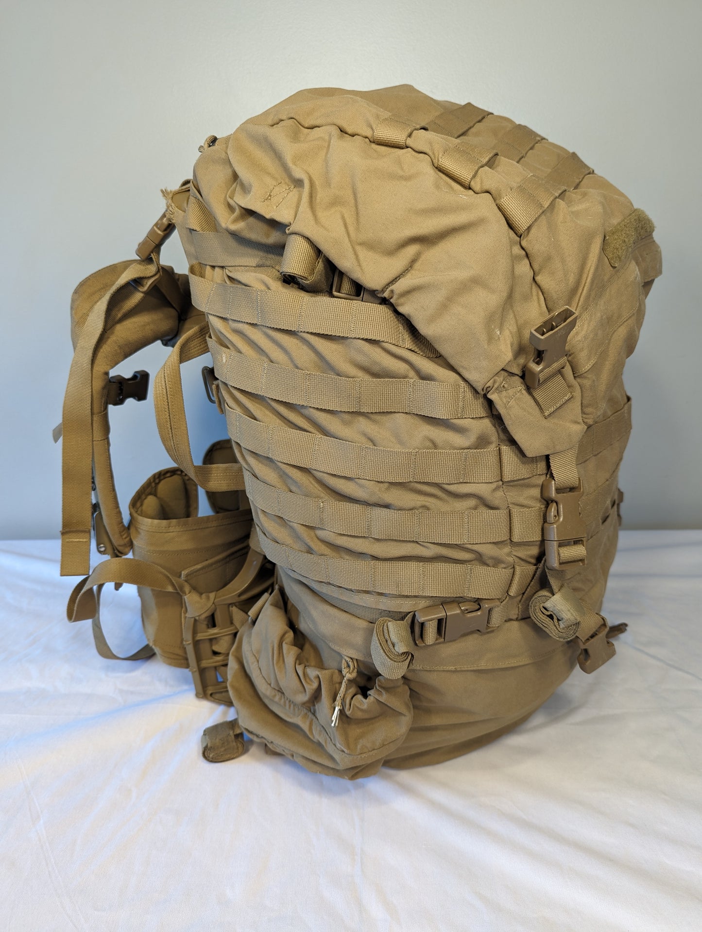 Tan military-style backpack on a white background