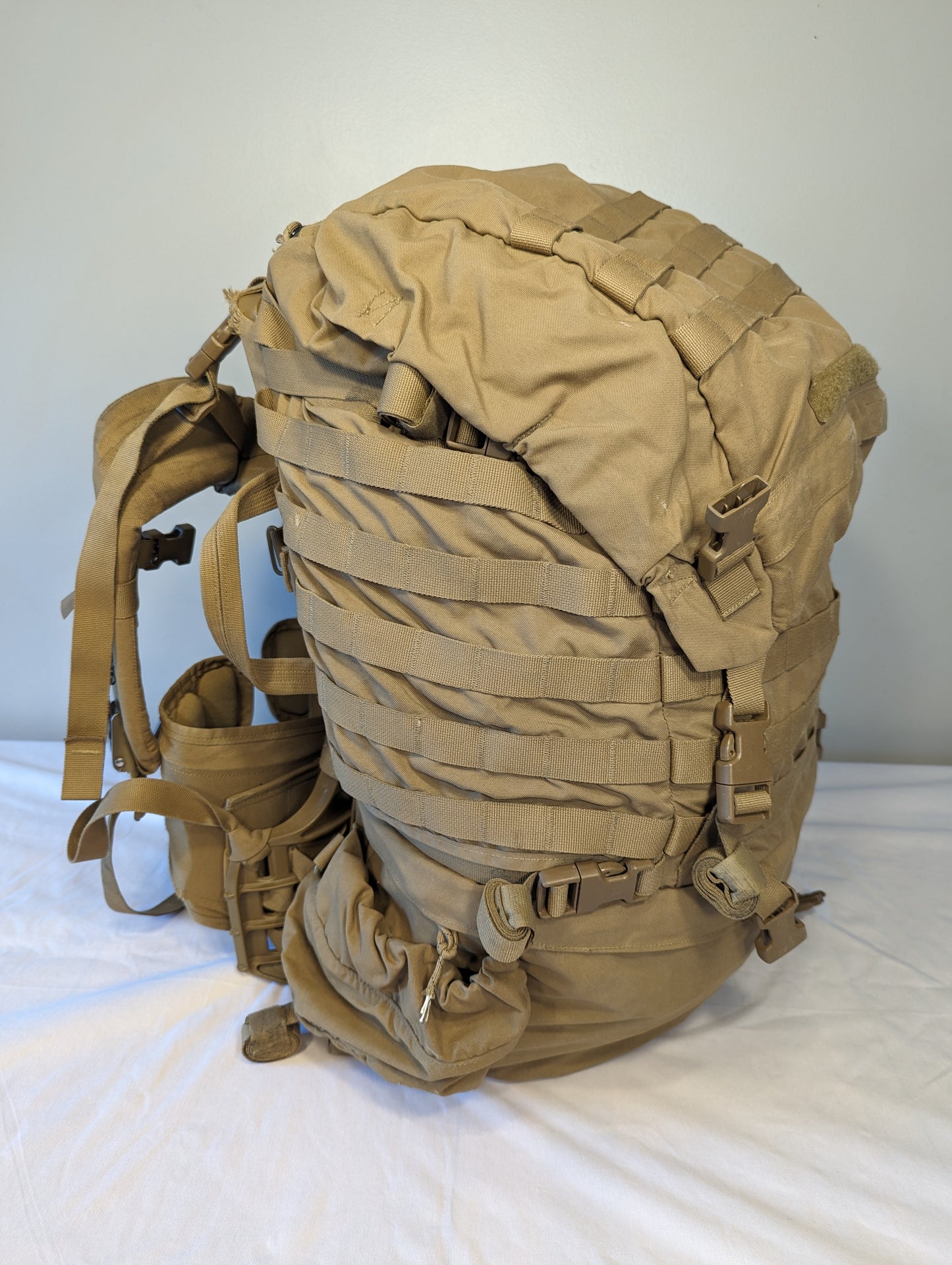 Tan military-style backpack on a white background