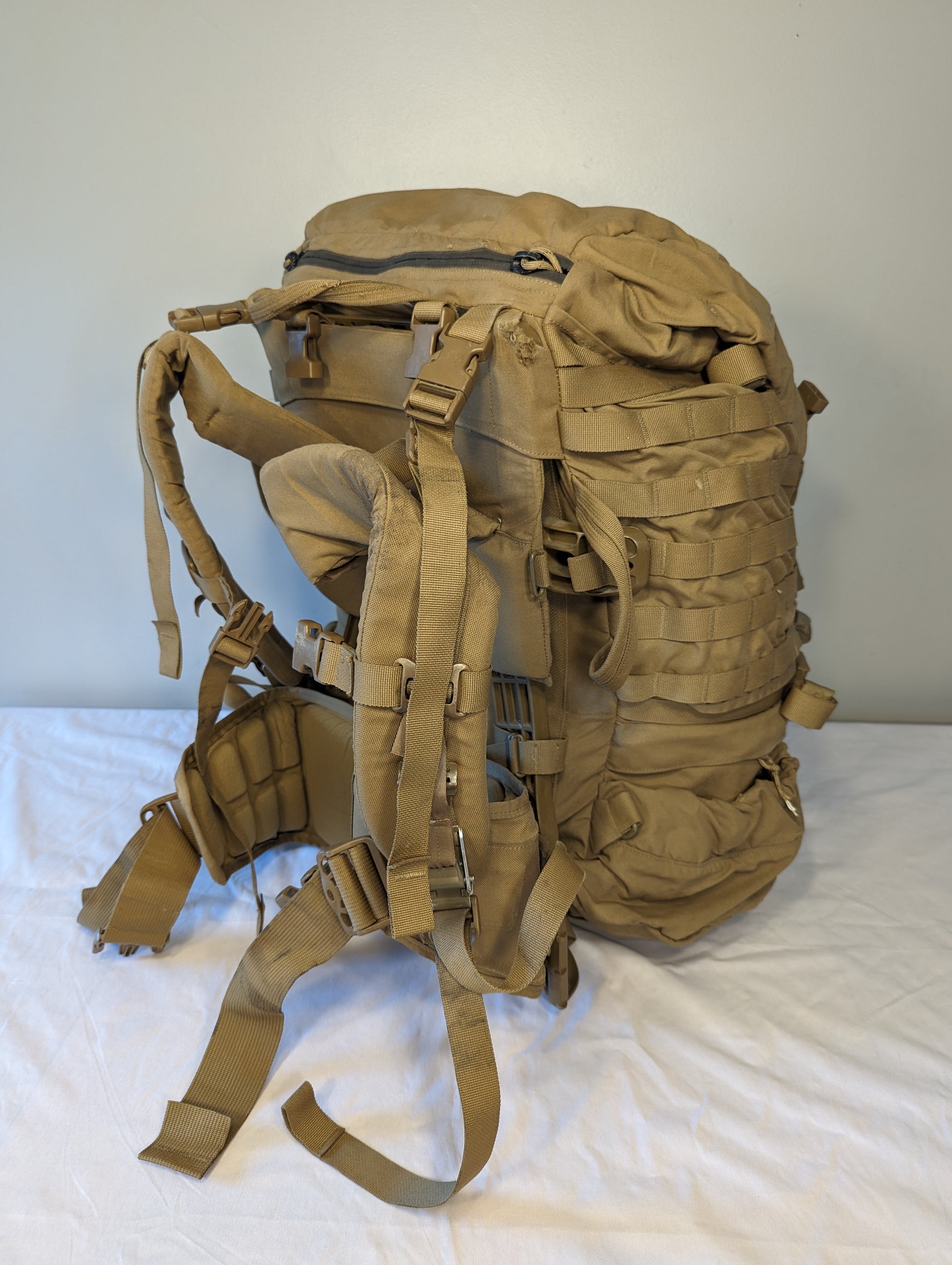 Tan military-style backpack on a white background
