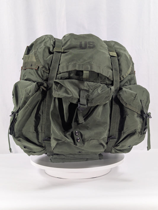 Green military-style backpack on a white background
