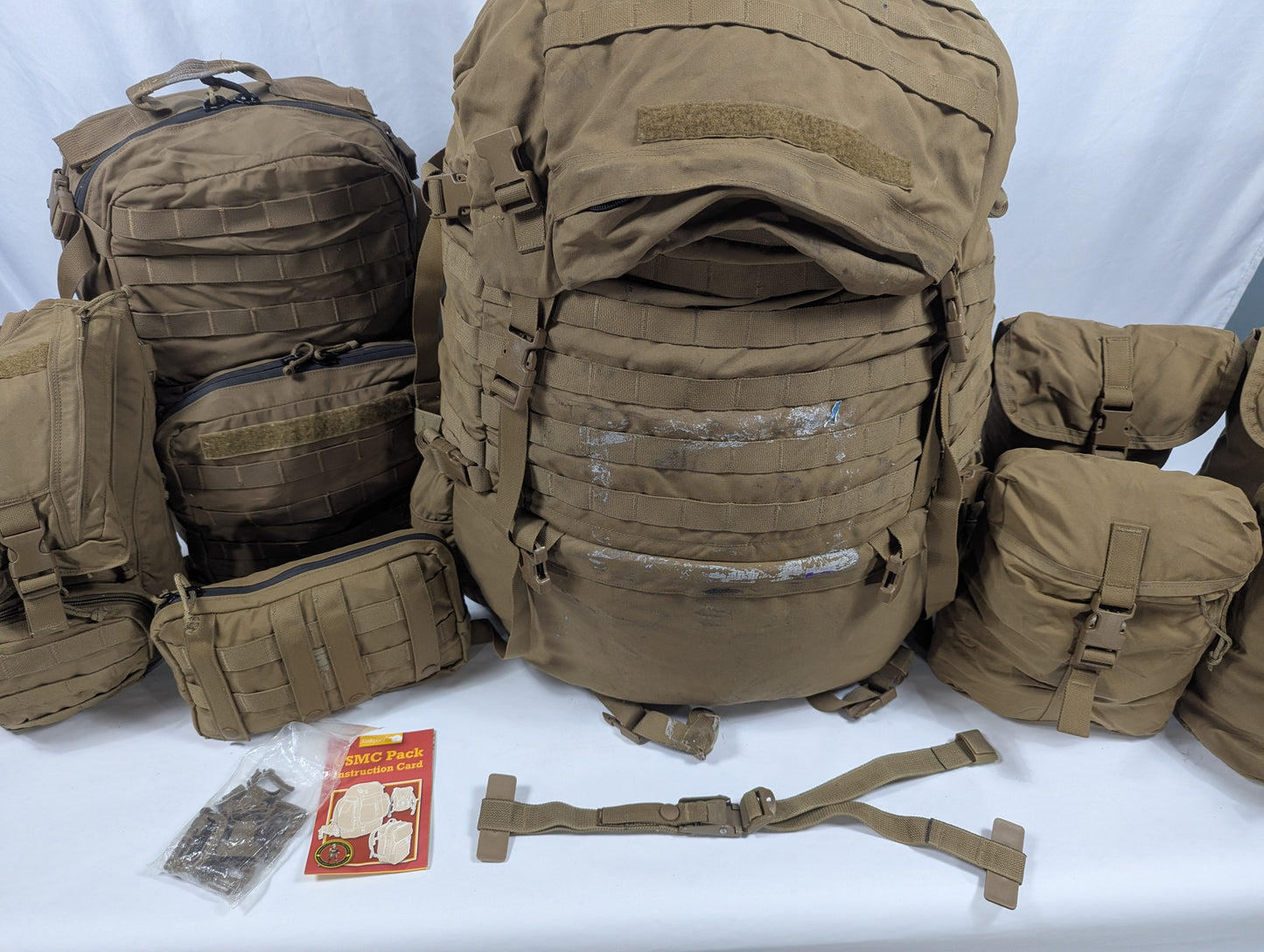 Collection of brown tactical backpacks and accessories on a white background