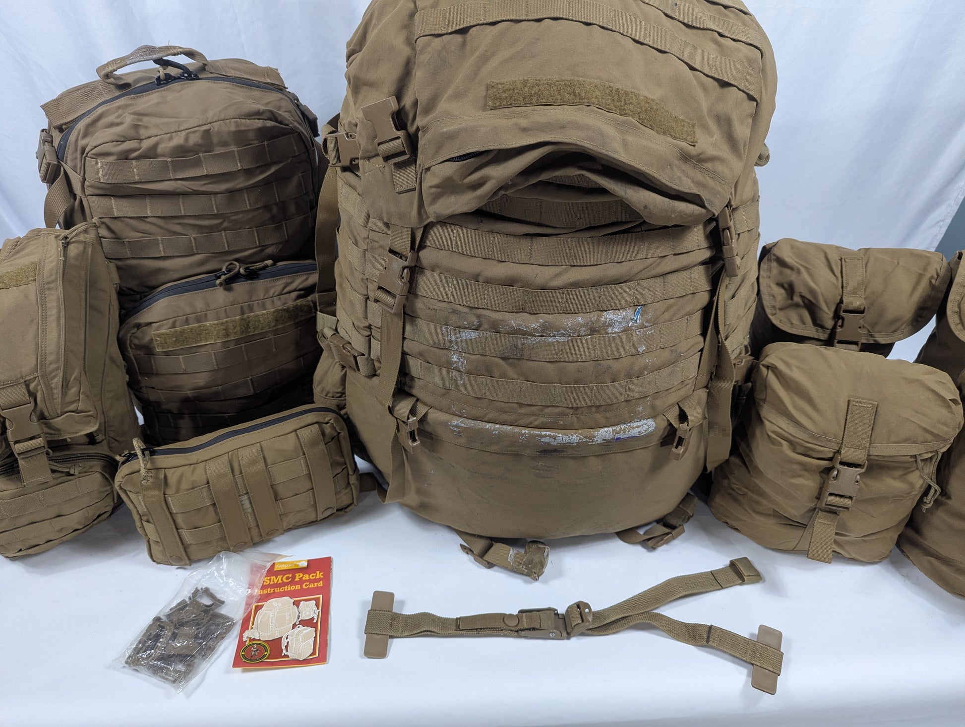 Collection of brown tactical backpacks and accessories on a white background