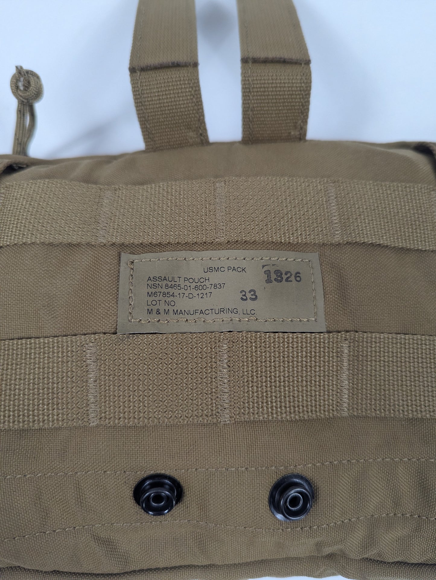 Tan military-style pouch with a label on a white background