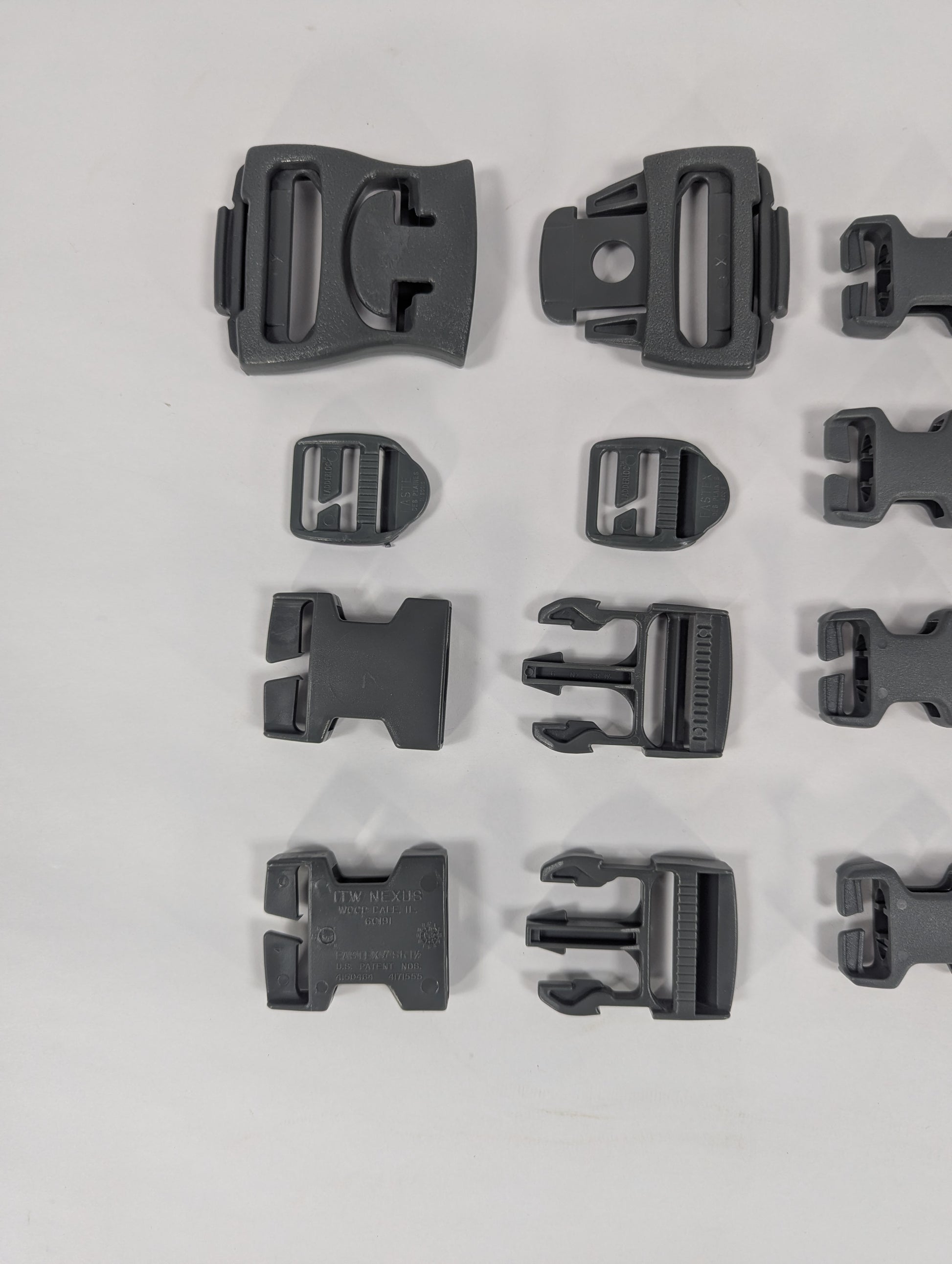 Multiple black plastic buckles arranged on a light gray background