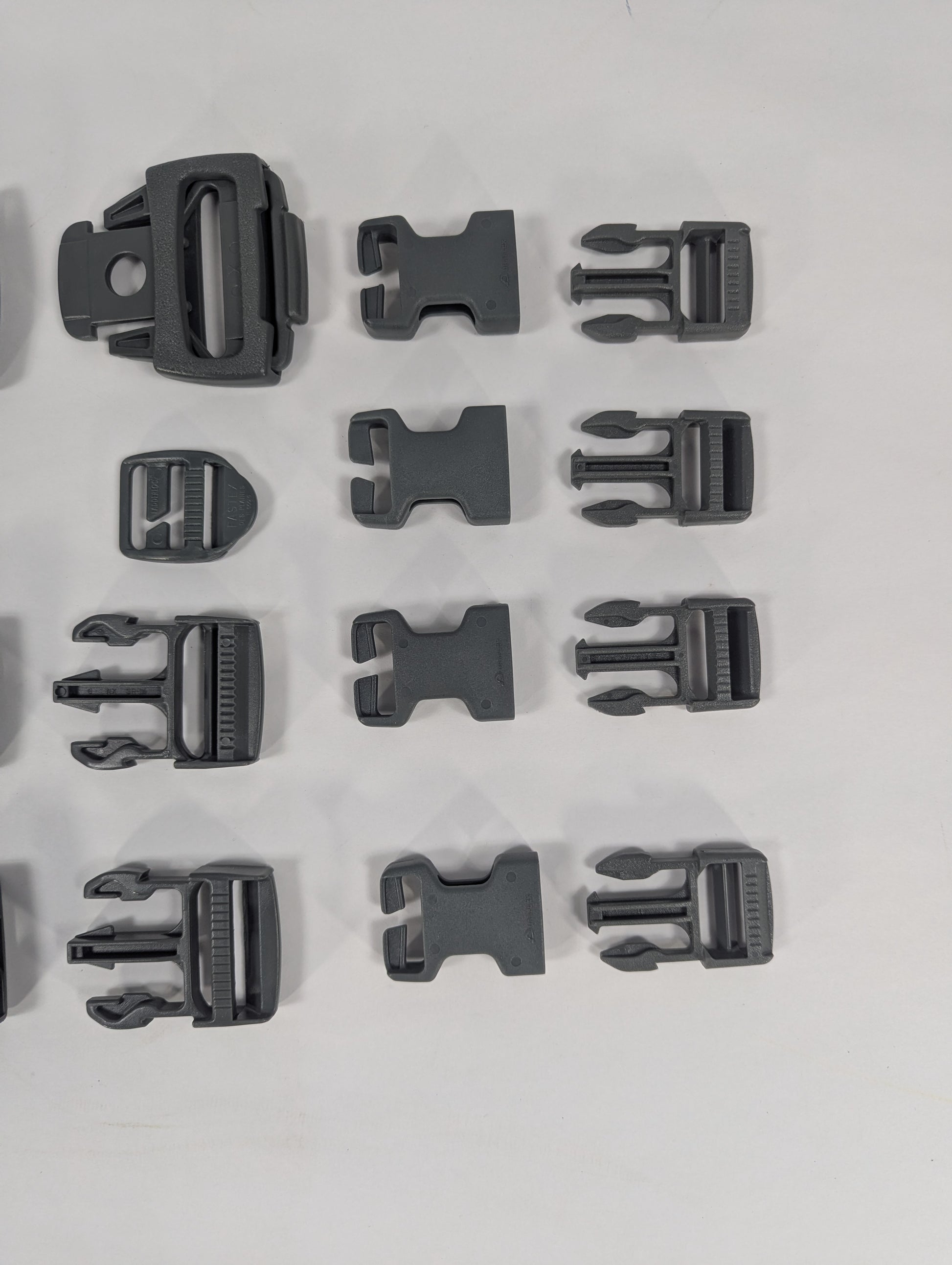 Set of black plastic buckles arranged in a grid on a white background