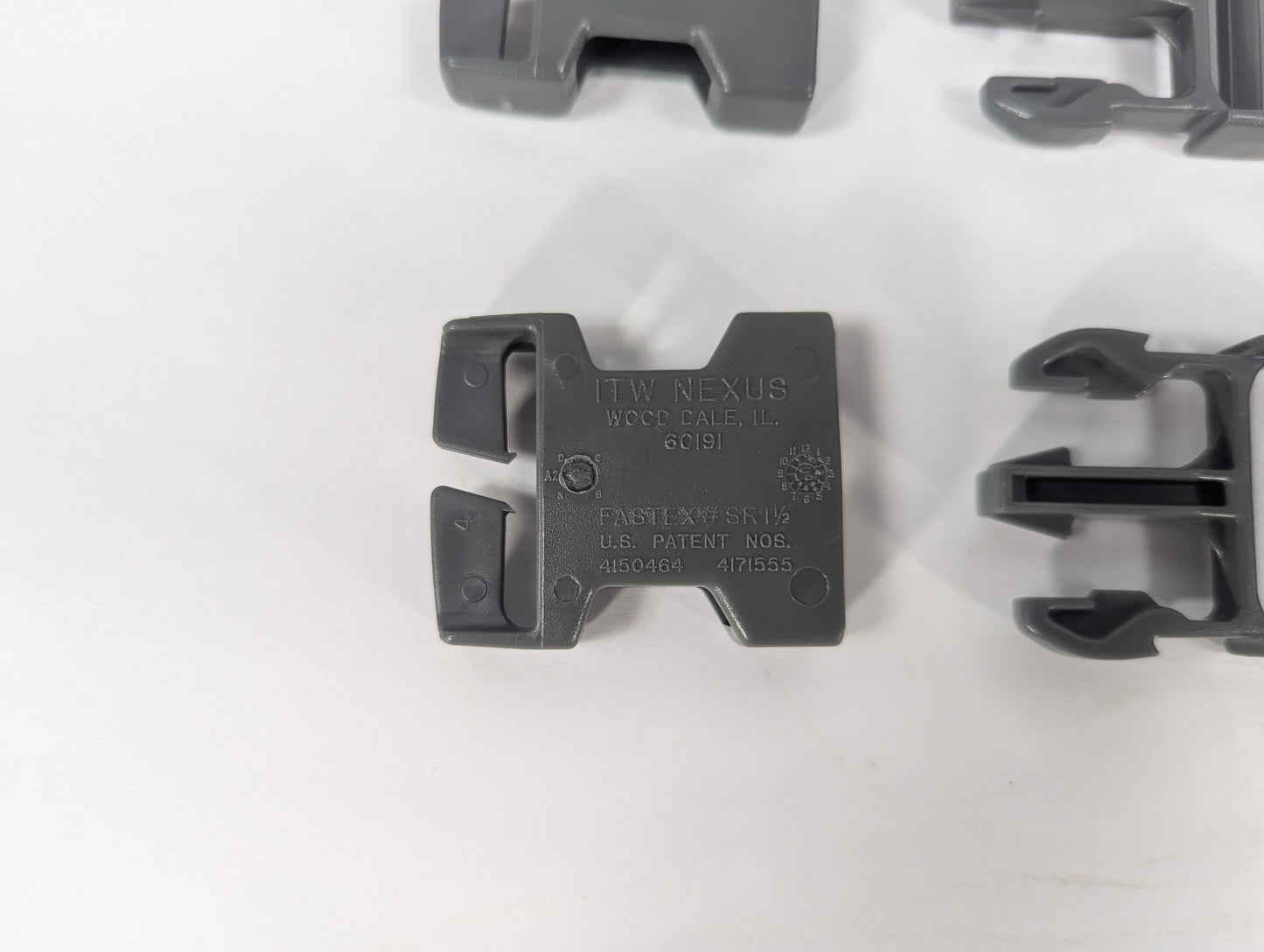 Gray plastic component with branding on a white background