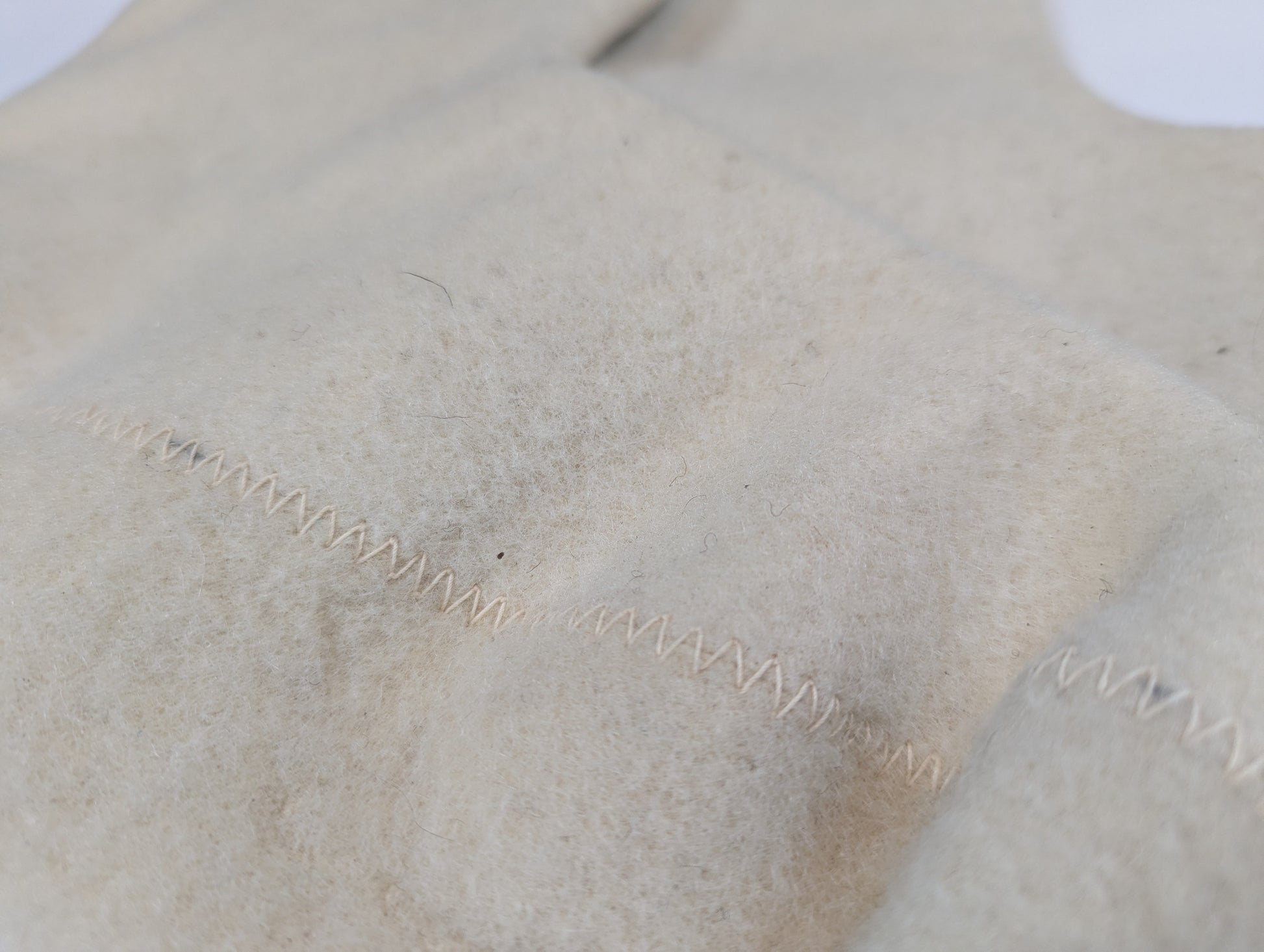 Close-up of beige fabric with visible stitching