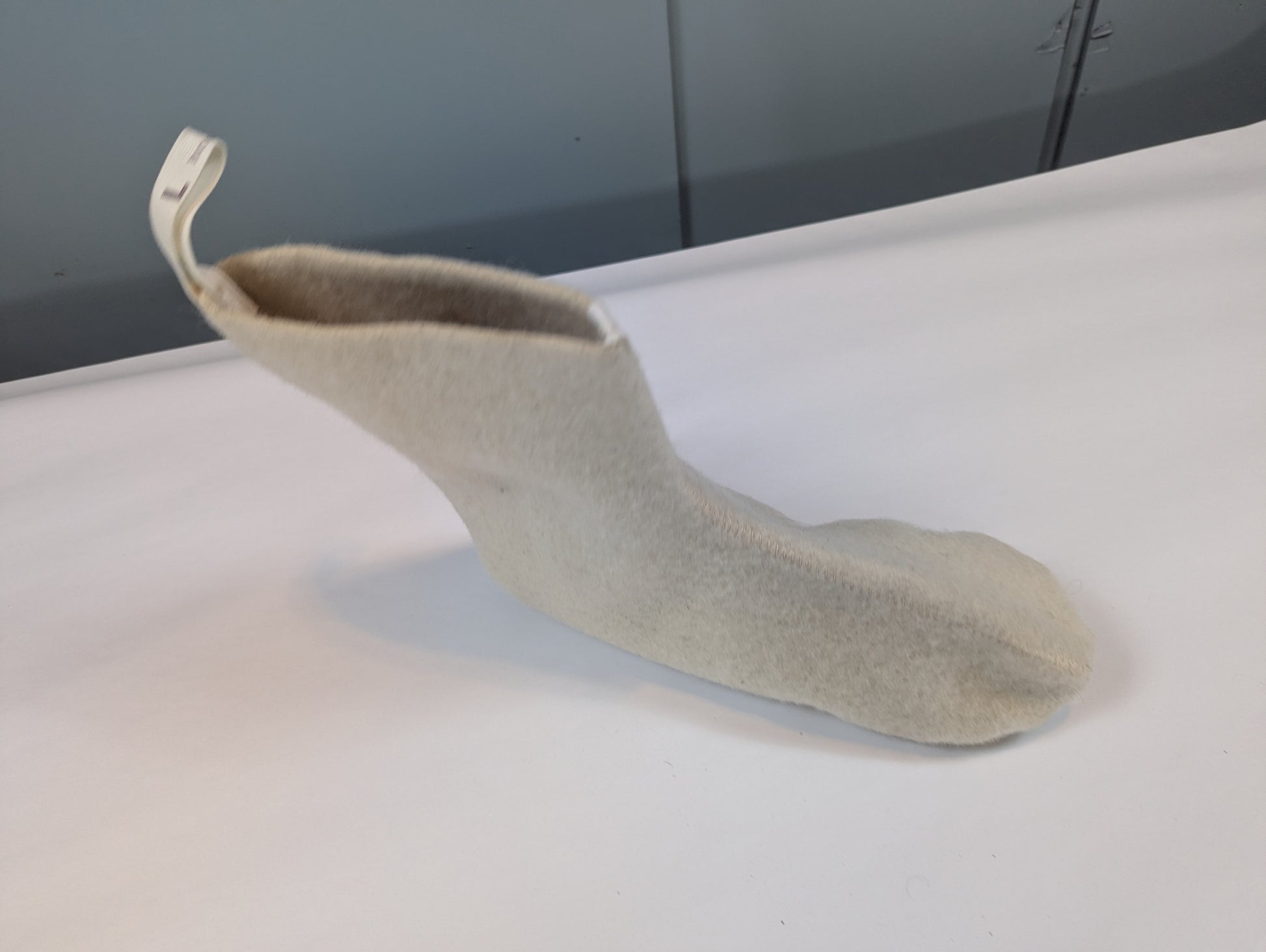 Gray sock on a white surface with a dark background