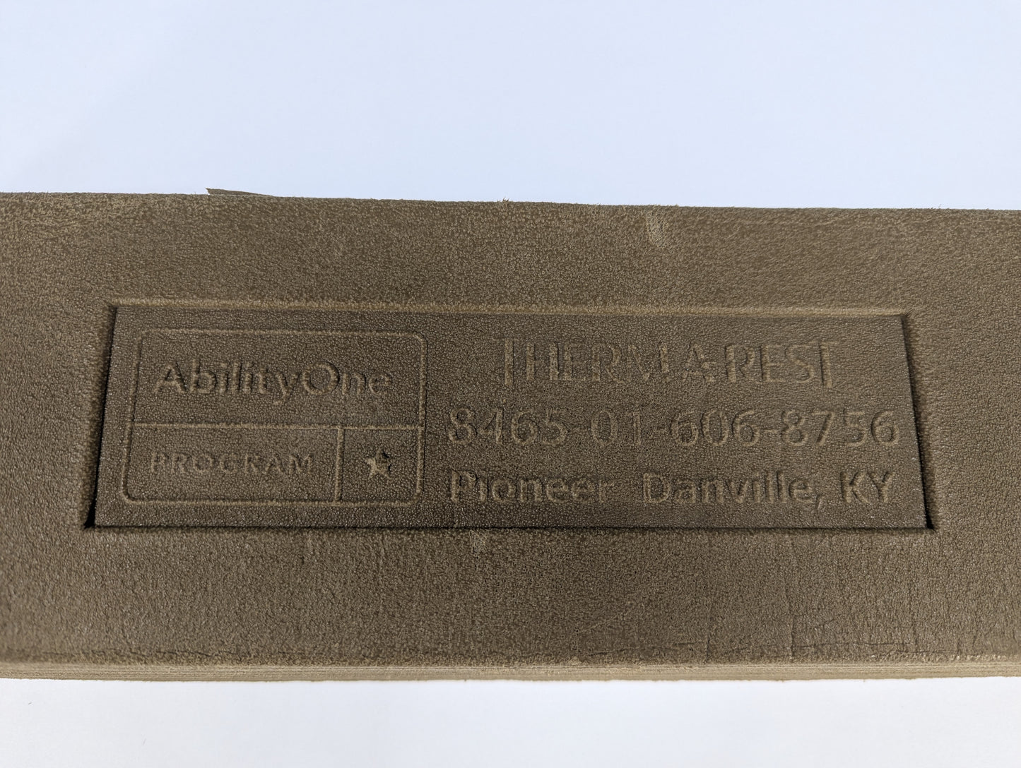 Brown fabric with embossed text and logo on a white background