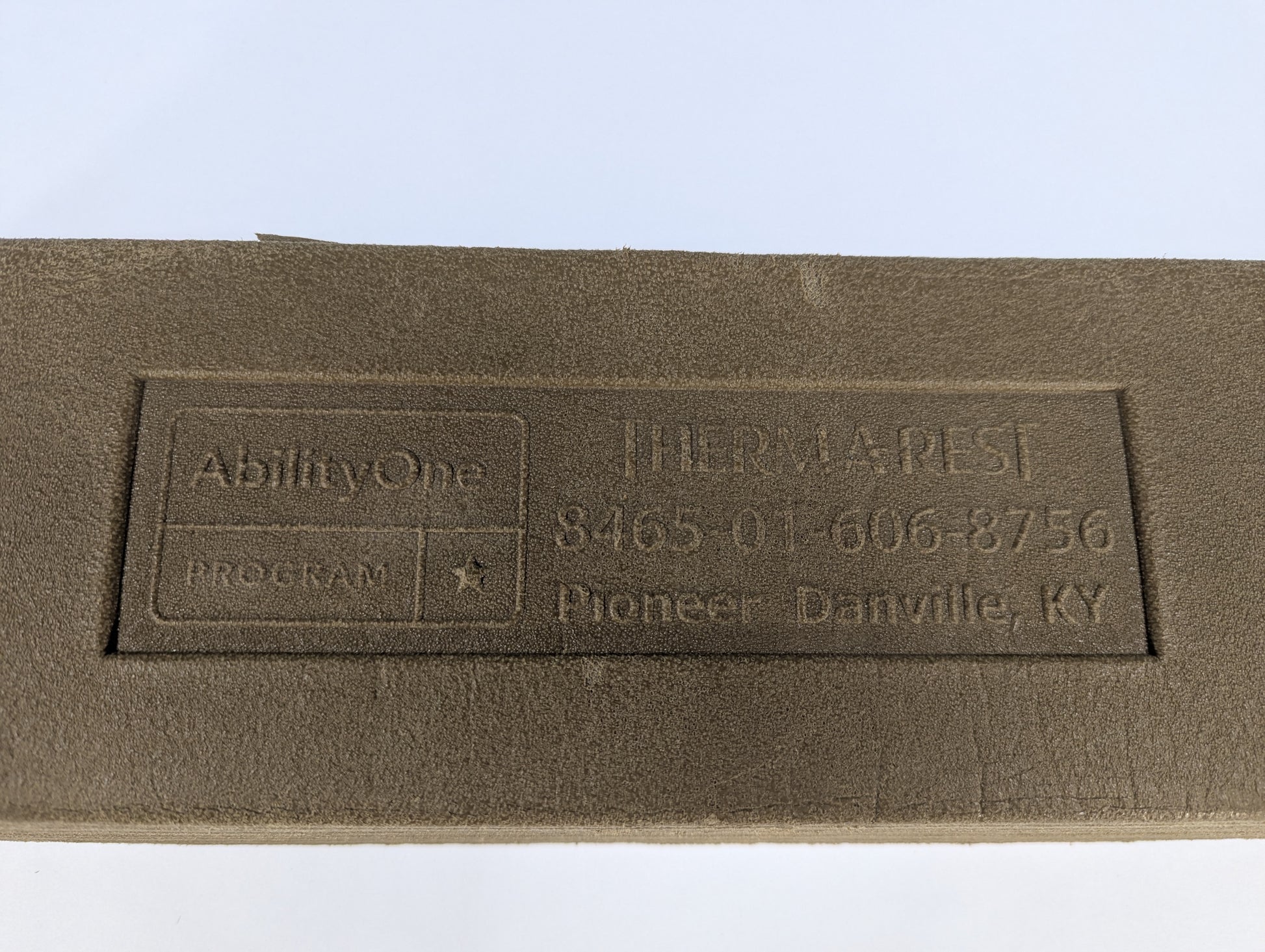 Brown fabric with embossed text and logo on a white background