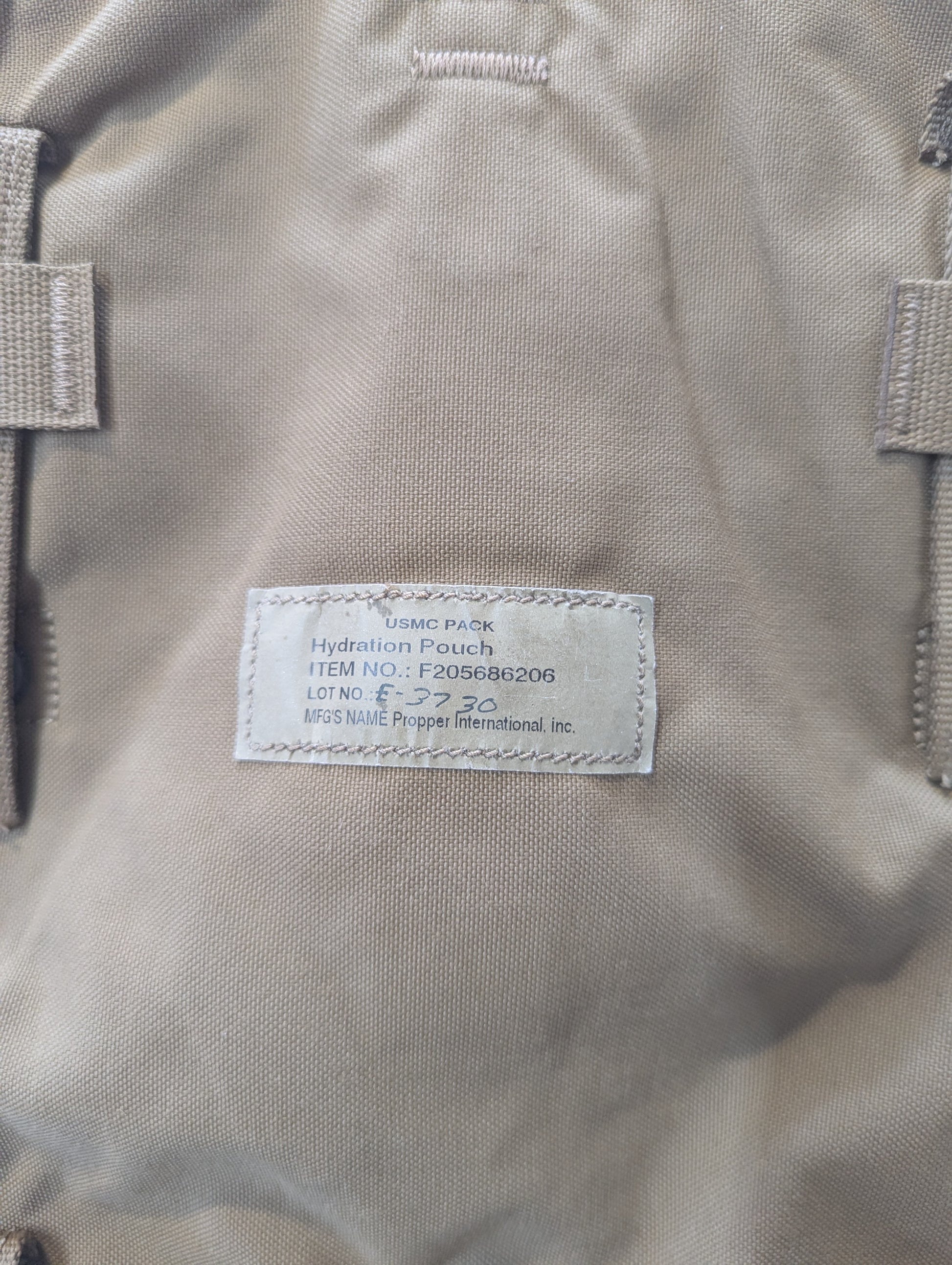 Close-up of a coyote hydration pouch with a label