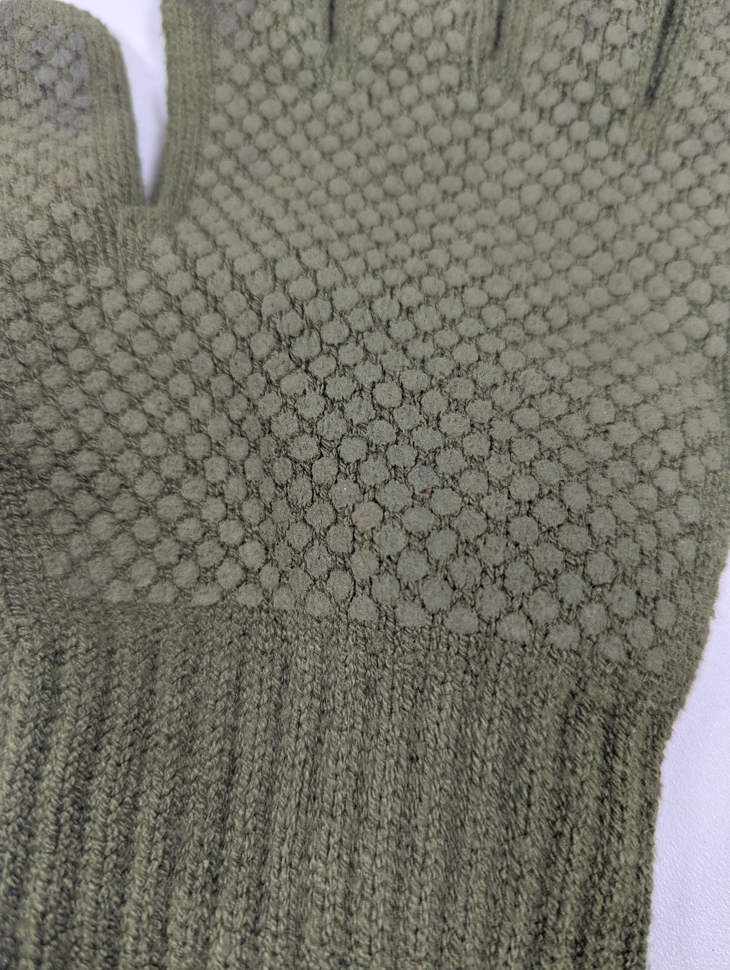 Close-up of a green textured glove on a white background