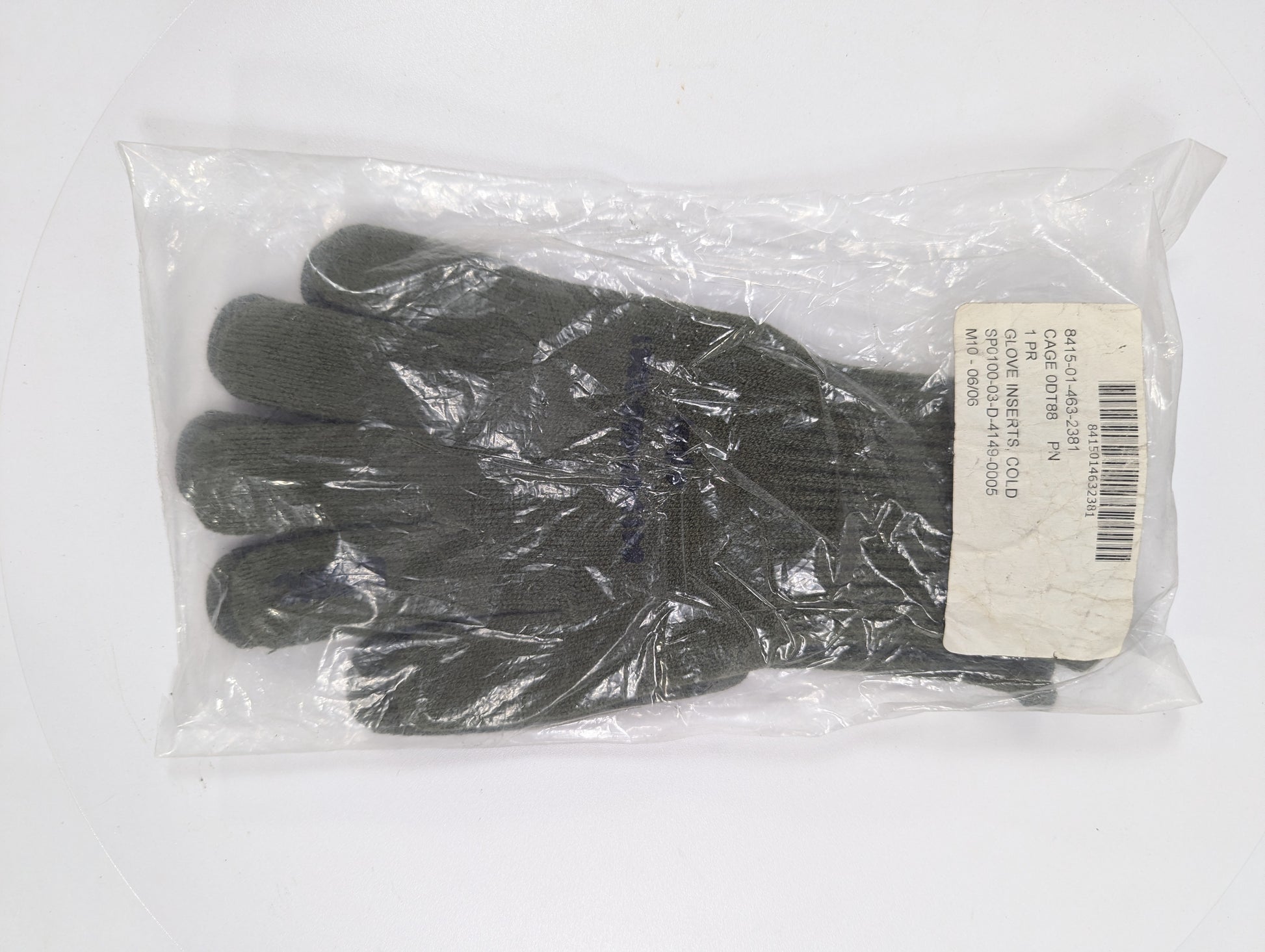 Pair of black gloves in a clear plastic bag with a label on a white background