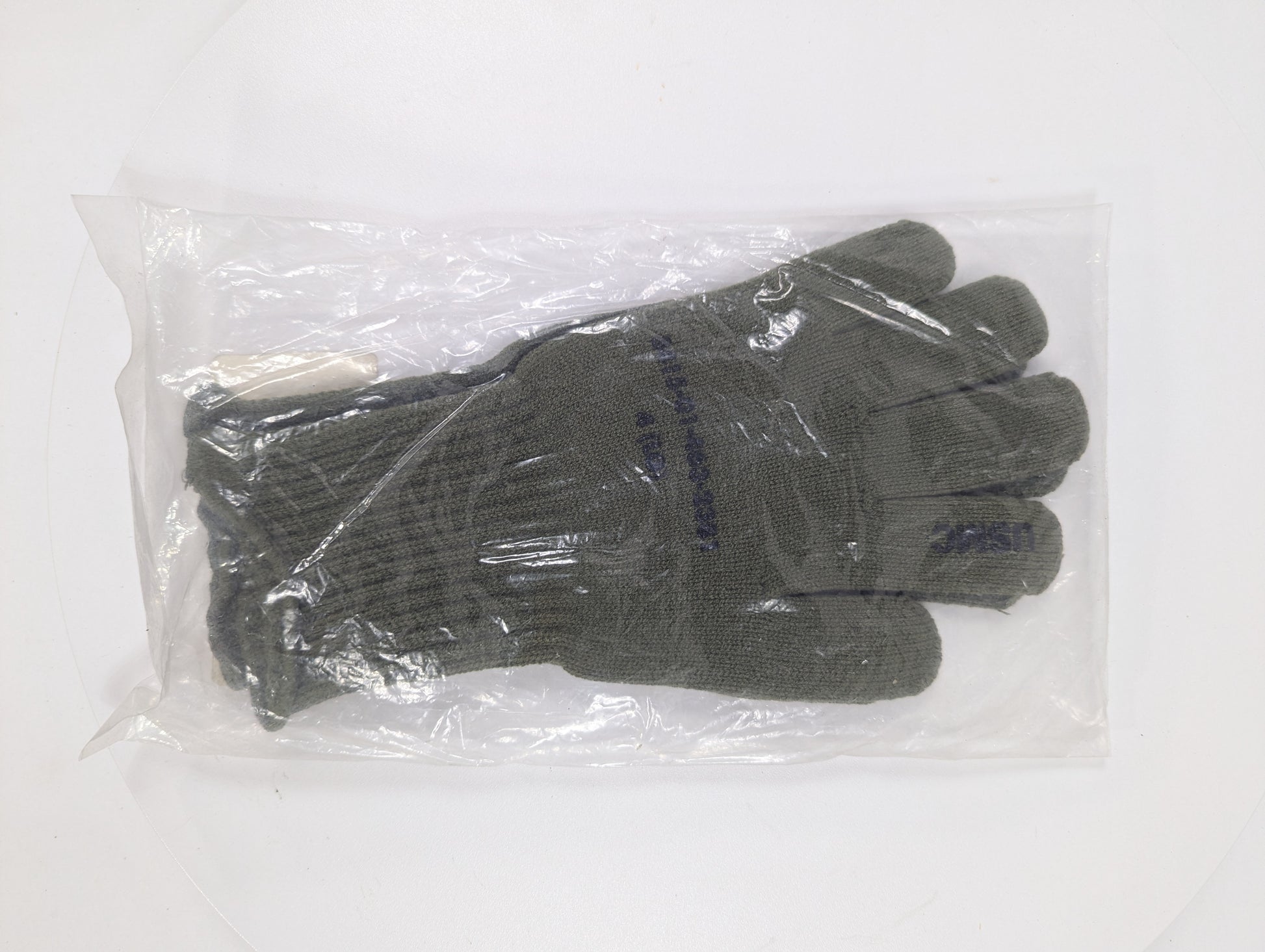 Pair of gray gloves in clear plastic packaging on a white background