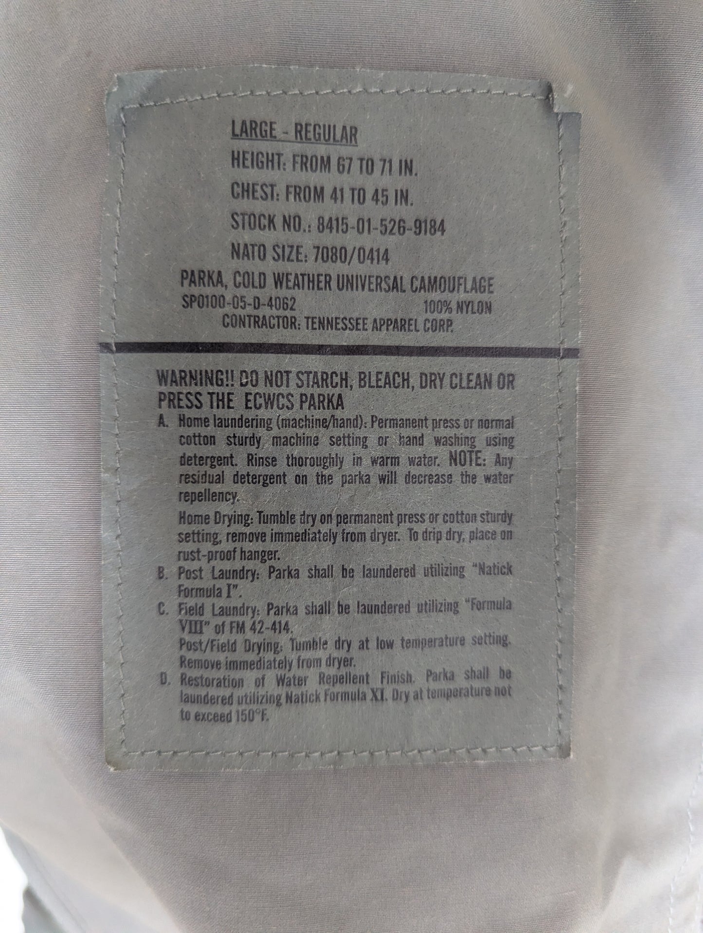 Label on a military-style parka with text and specifications.