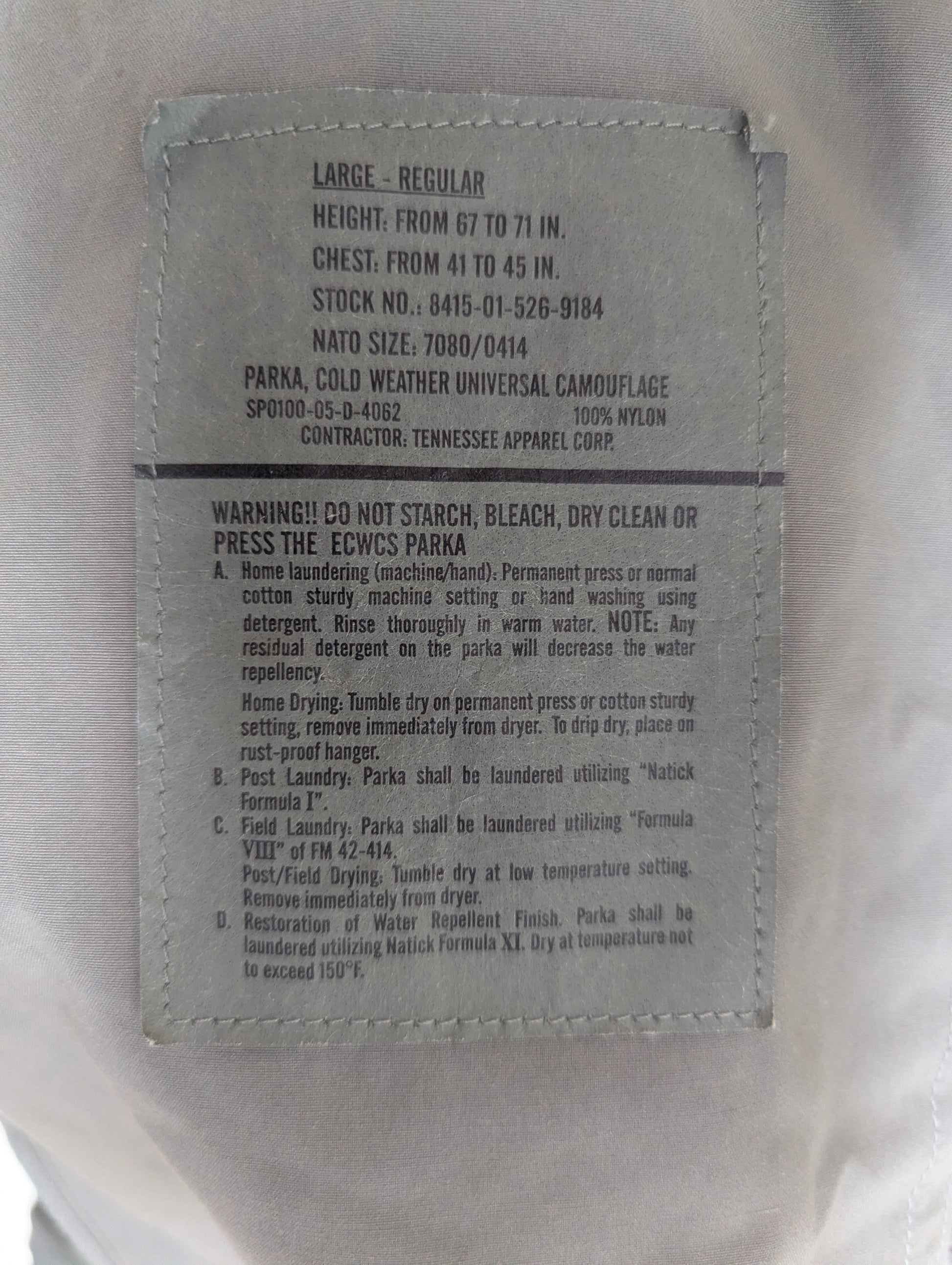 Label on a military-style parka with text and specifications.