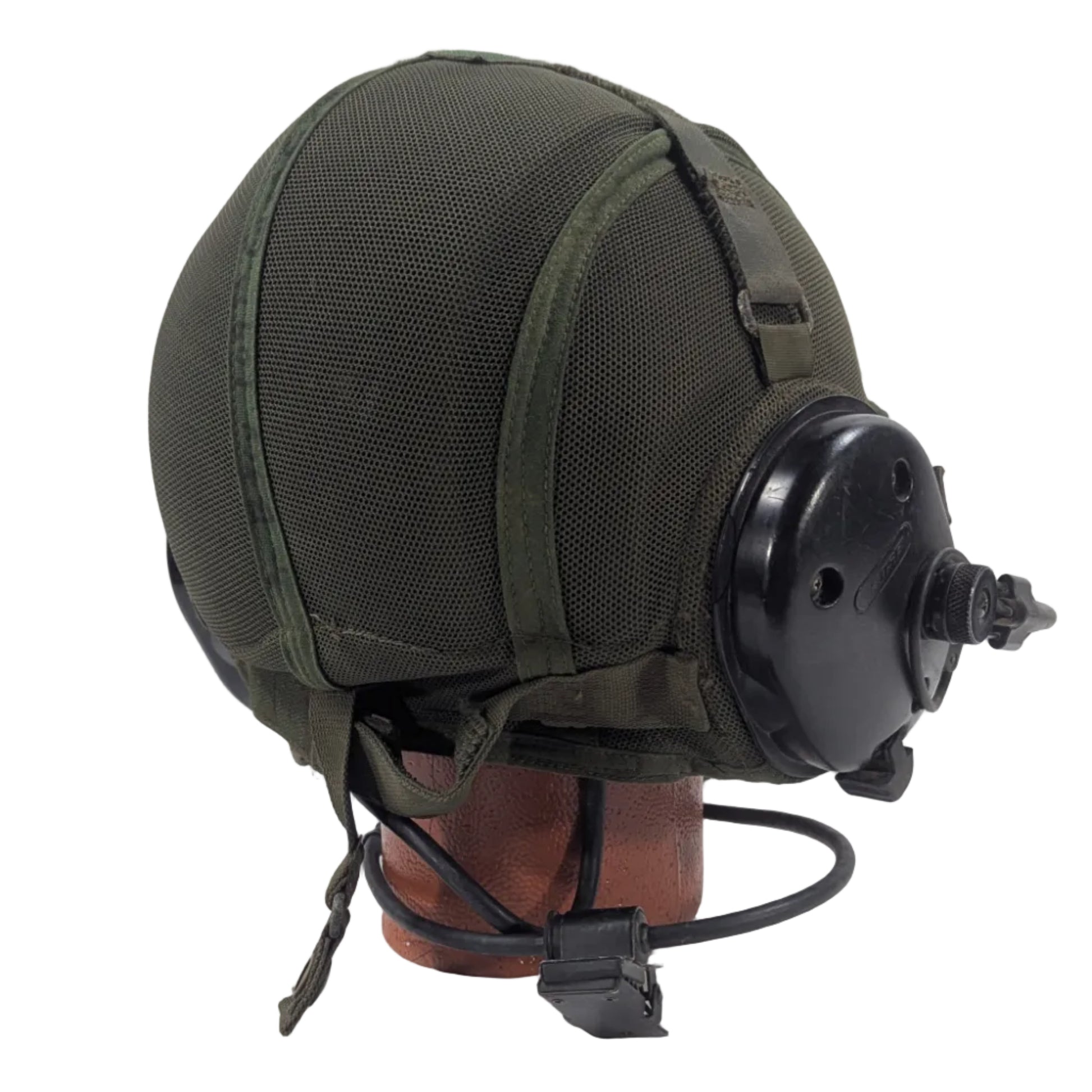 Green military helmet with attached communication headset on a white platform