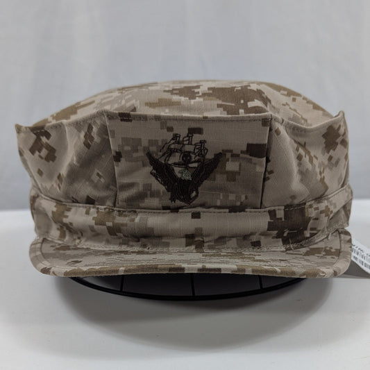 Camouflage military hat on a white surface with a gray background