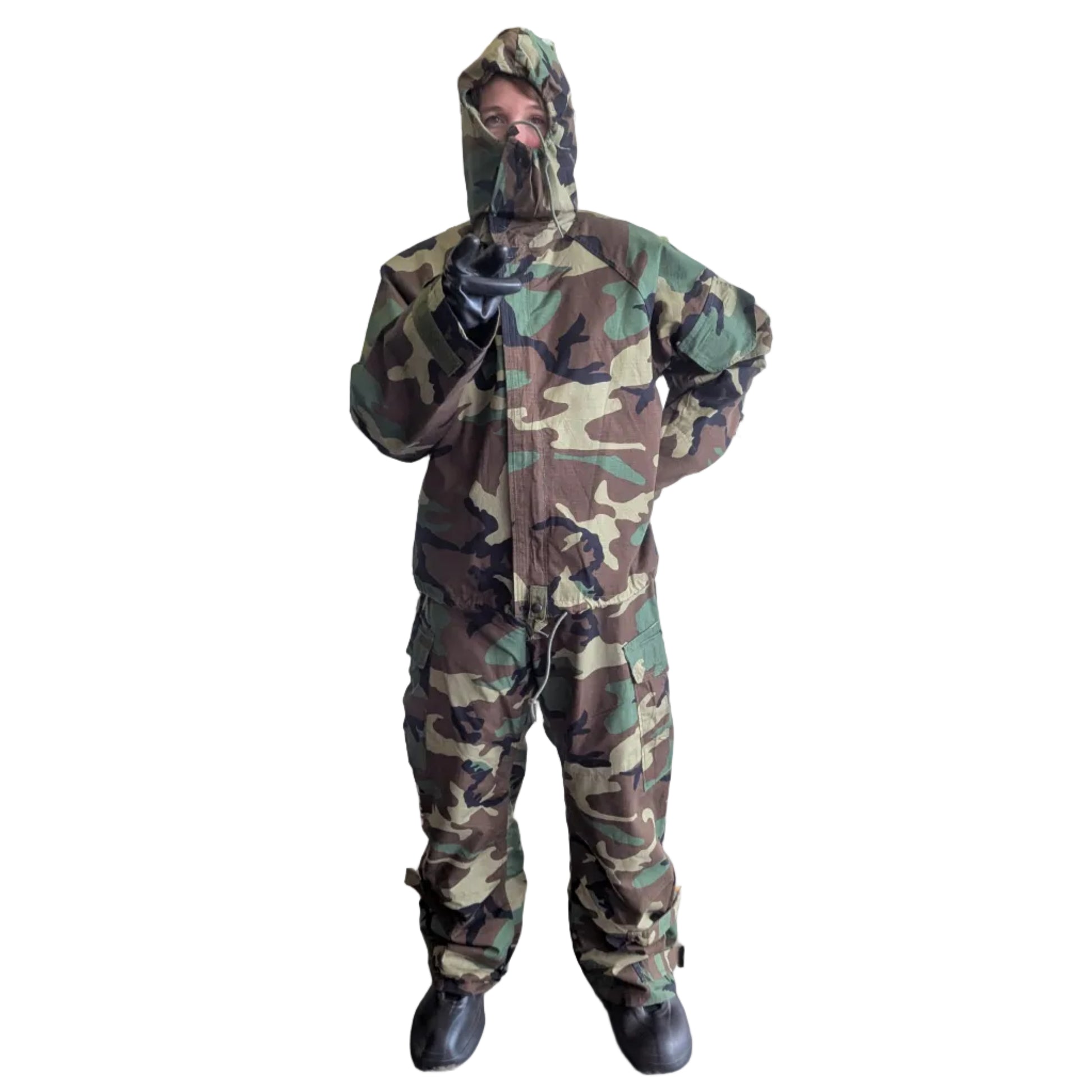 Person in camouflage snowsuit with gas mask in front of a mural with 'Fortitude' text.