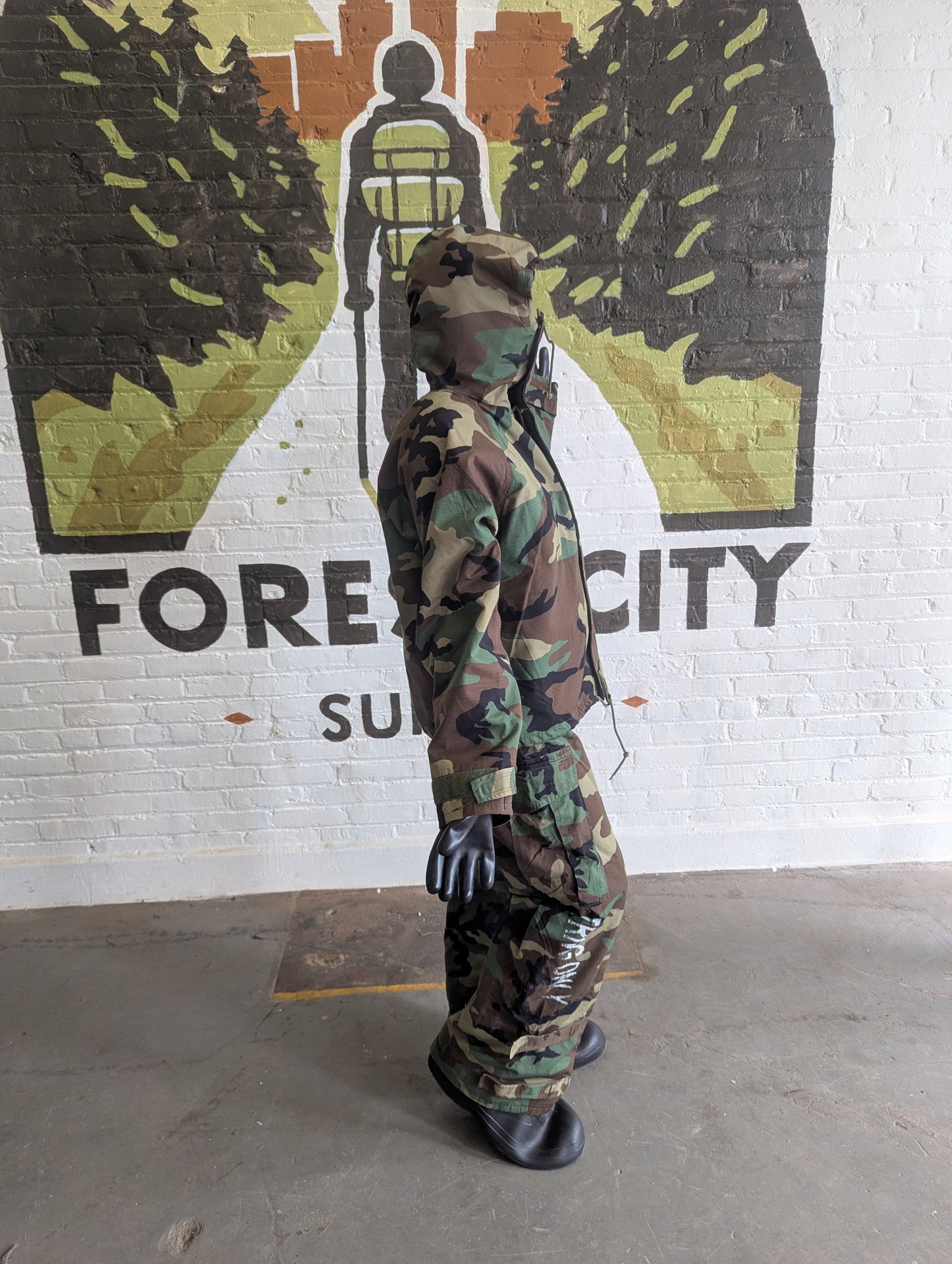 Person in camouflage outfit standing in front of a mural with 'FORECITY' branding.