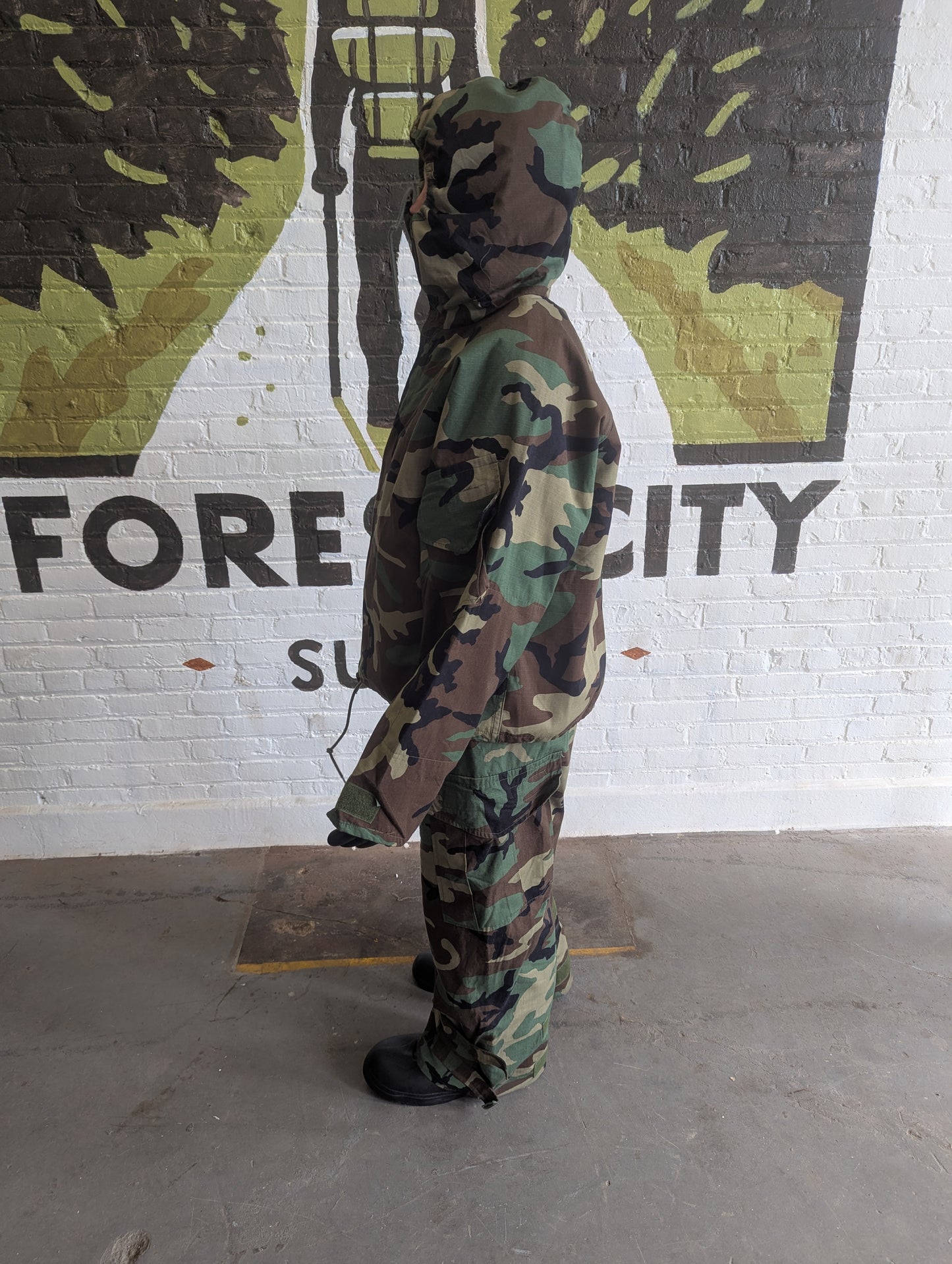 Person wearing a camouflage outfit standing in front of a mural with 'FORECITY' branding.