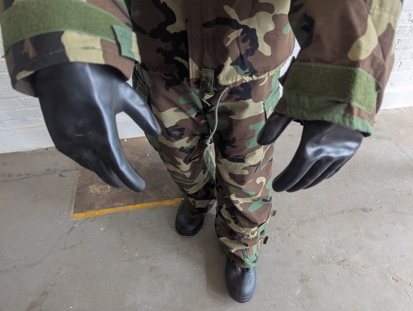 Camouflage pants with black gloves on a mannequin against a plain background