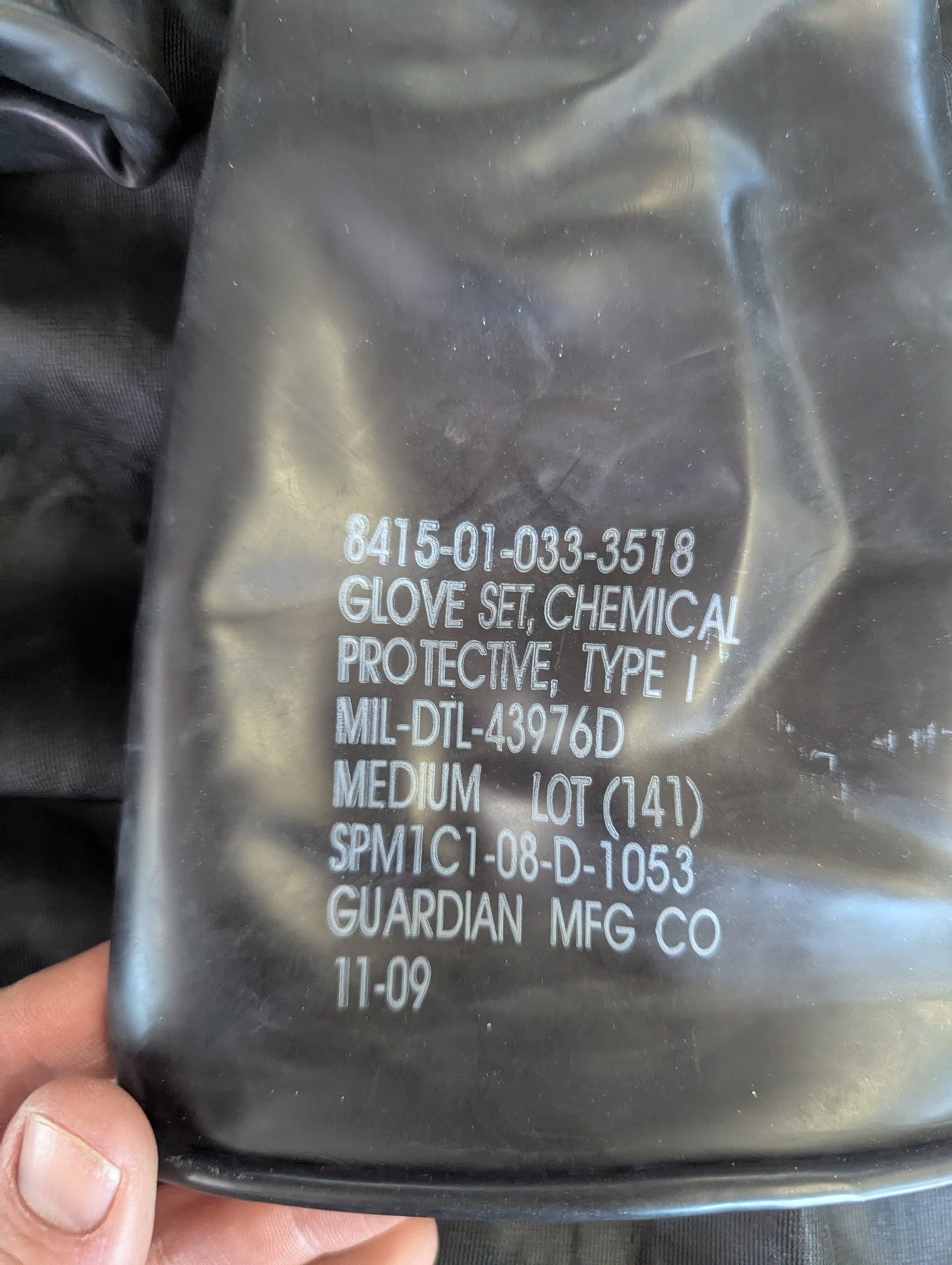 Black protective glove packaging with text on a dark background