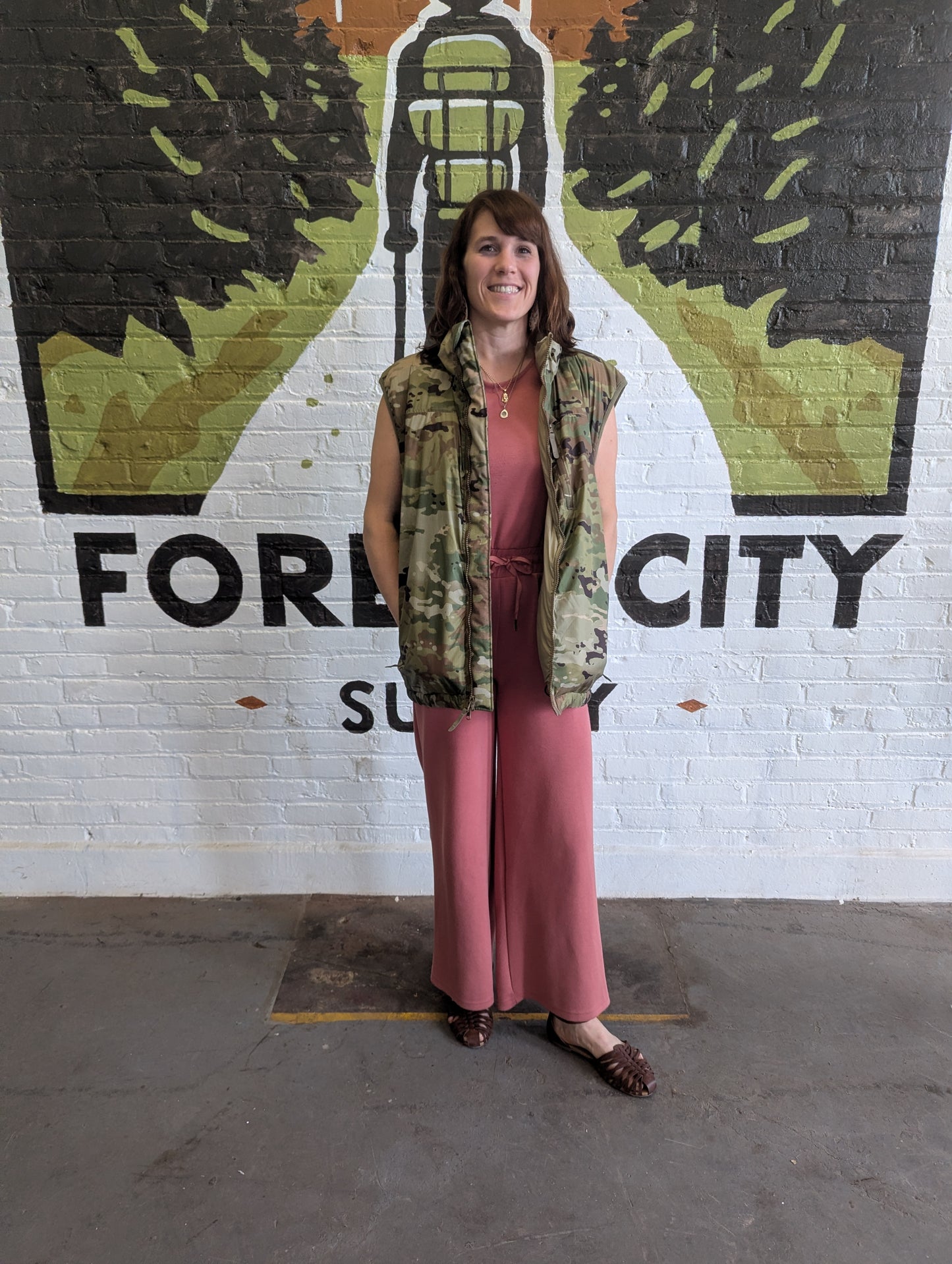 Woman standing in front of a mural with 'Fore City' text and design.
