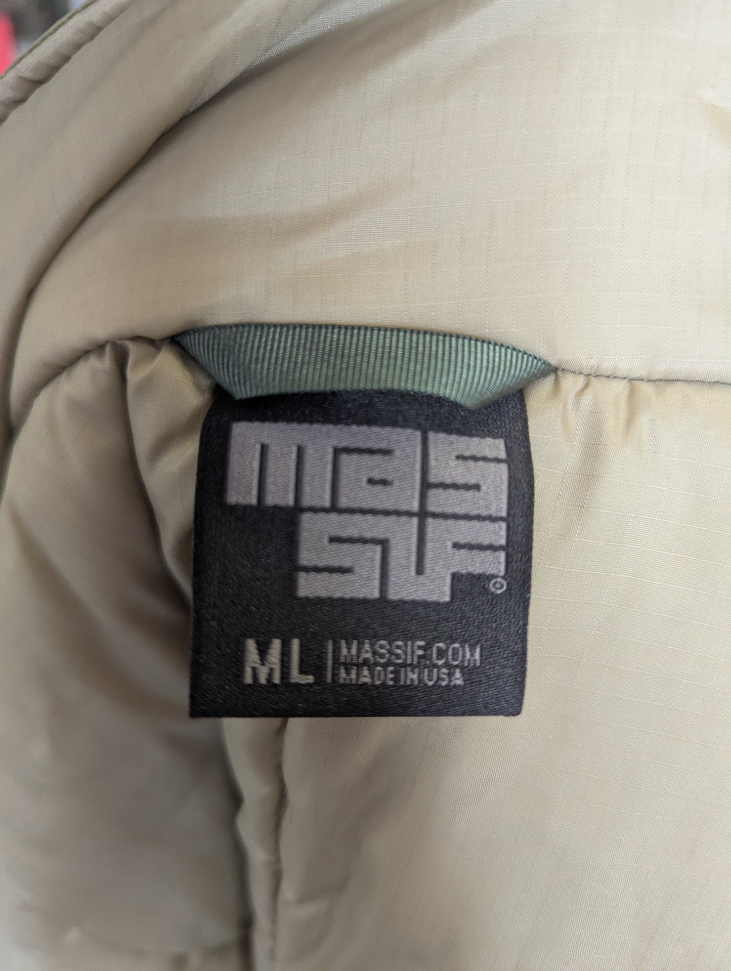 Close-up of a Massif Com label on a beige jacket