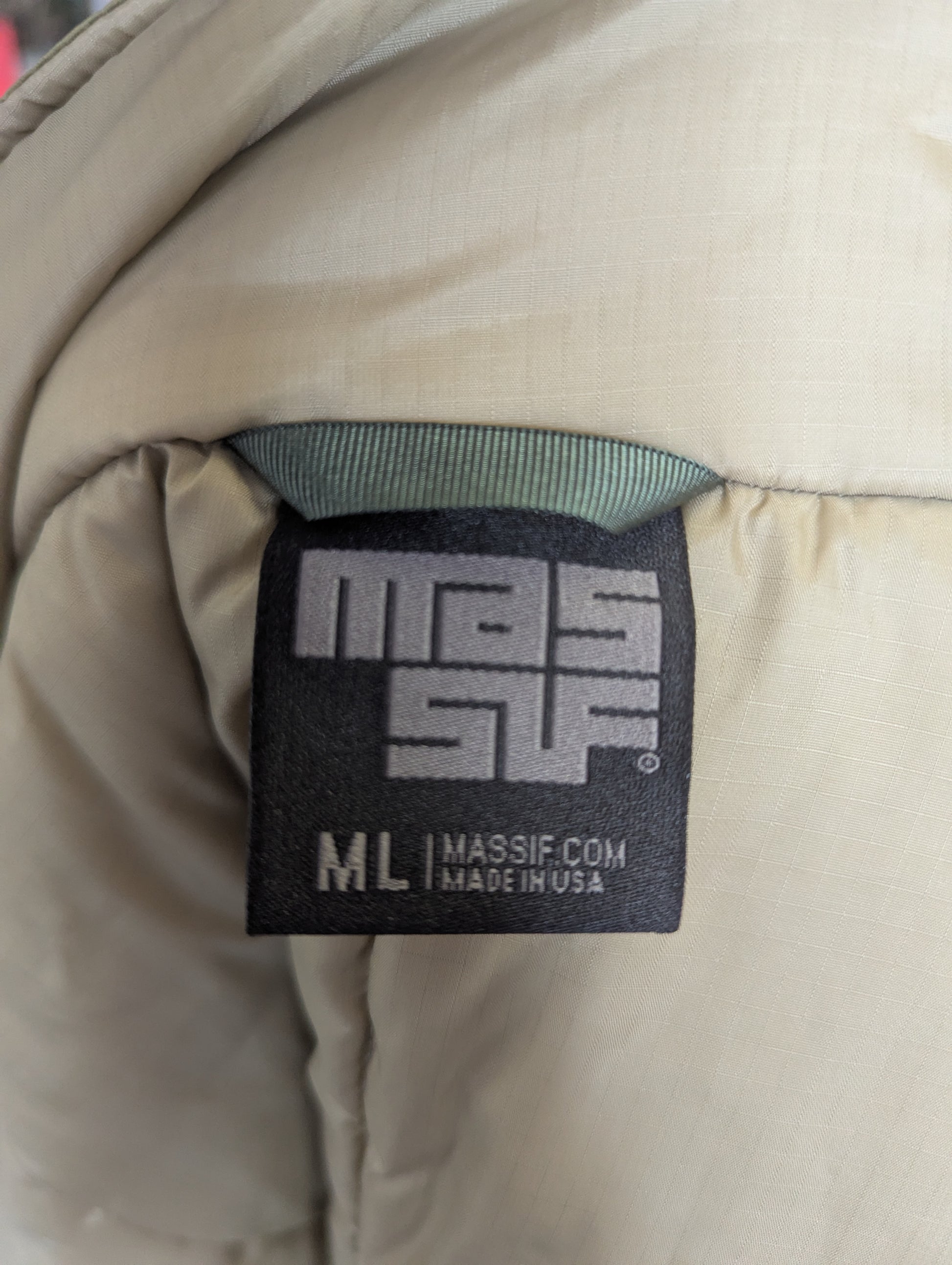 Close-up of a Massif Com label on a beige jacket