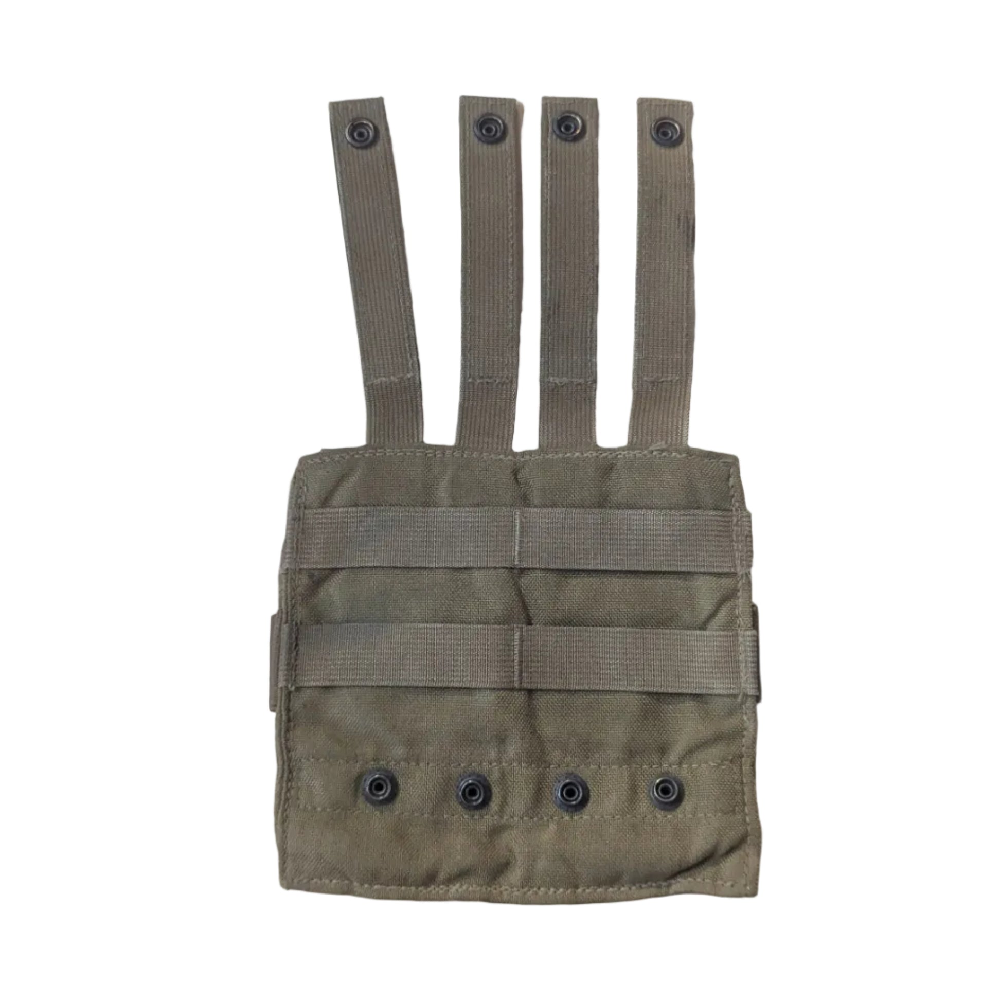 A tan tactical utility pouch with four webbing straps, laid flat on a light-colored wooden table. Parts of a person's legs and feet are visible on the left, and some camouflage fabric and a blue tool are visible on the right.