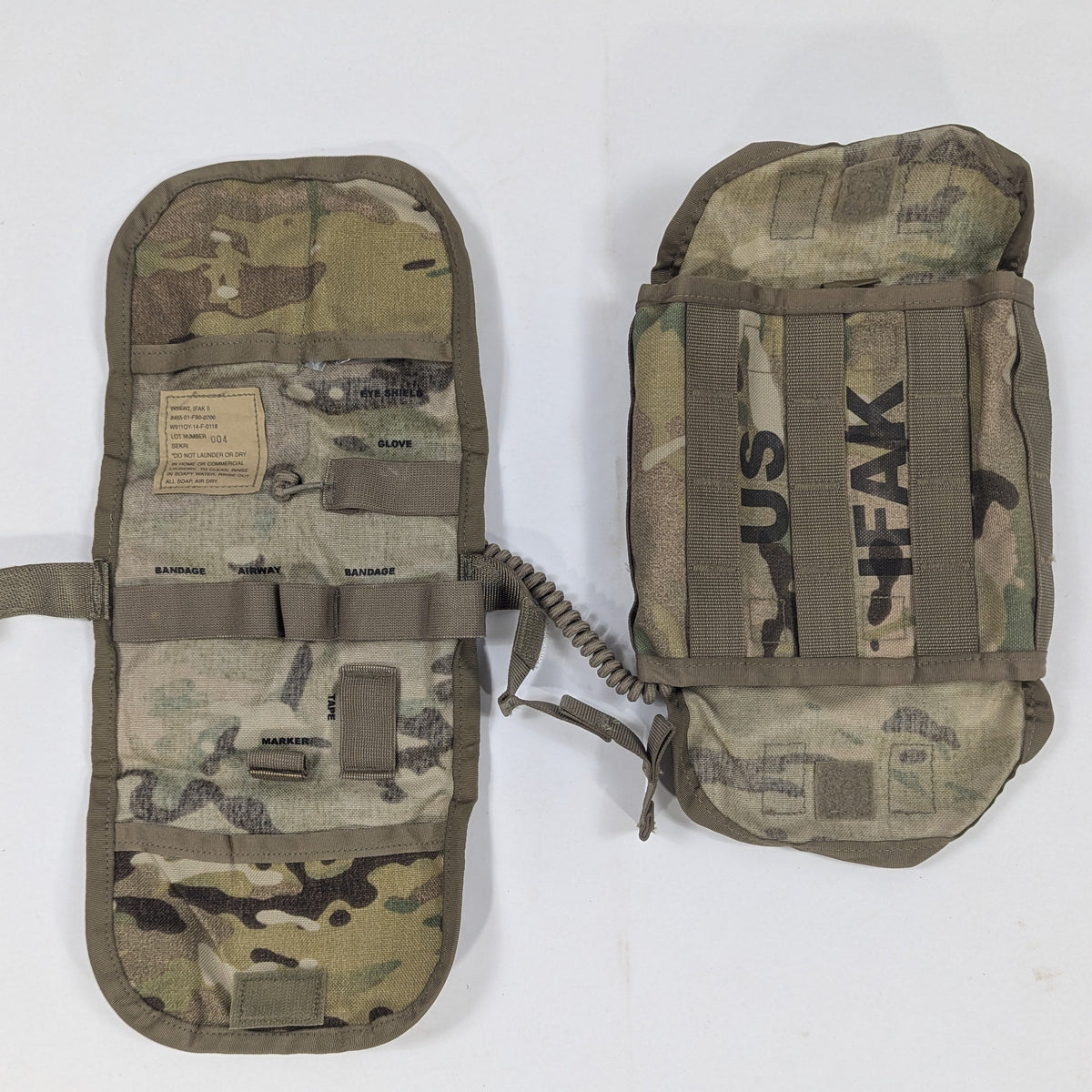 Two camouflage tactical utility pouches laid flat on a white surface, one above the other. The top pouch has black printed text reading 'SUS TEEK', and both pouches feature MOLLE webbing, velcro patches, and straps.