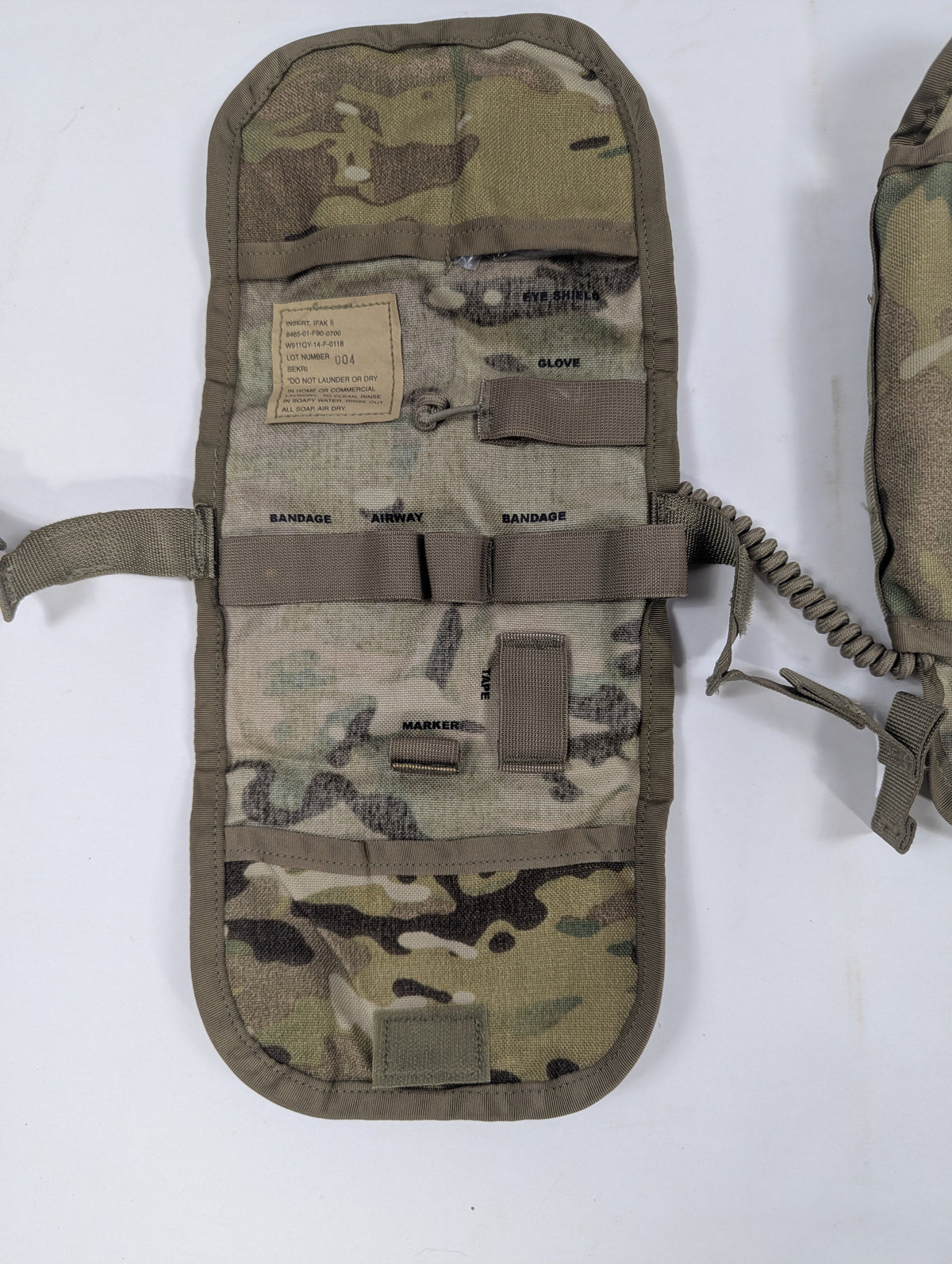 A camouflage tactical pouch with MOLLE webbing and a strap closure, laid flat on a white background.