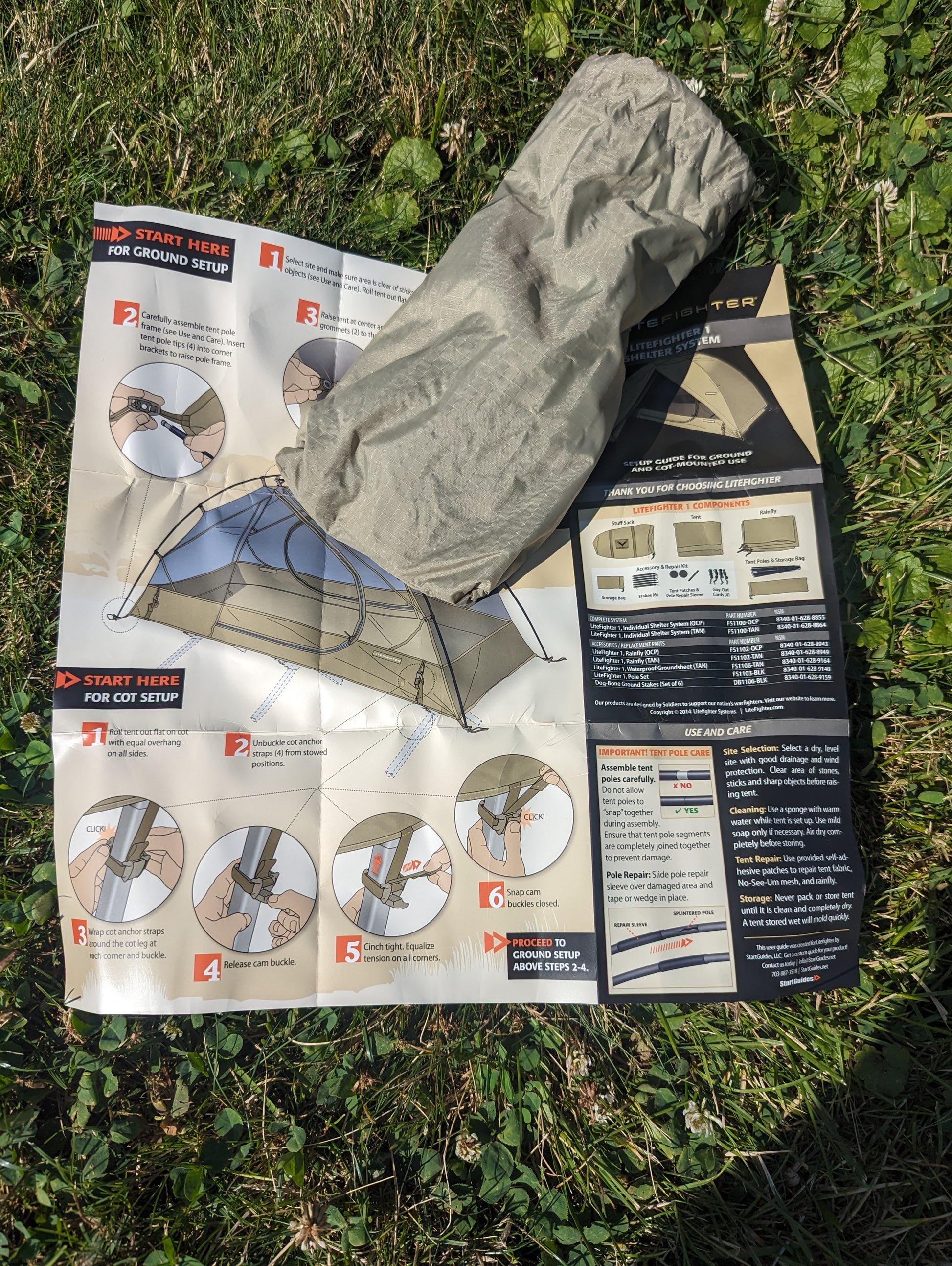 An overhead view of the U.S. Military Litefighter 1-Man Combat Shelter instruction manual laid on green grass, featuring setup diagrams and a bundled tan tent component.
