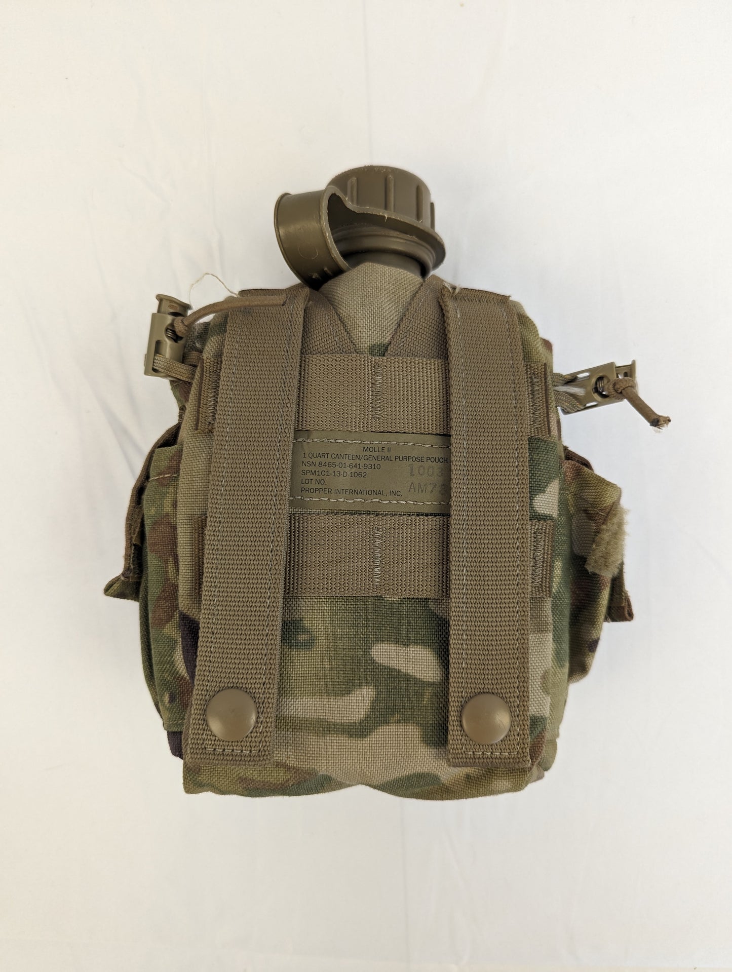 A back view of a U.S. Military 1-quart canteen in olive green, fully contained within a closed OCP/Multicam camouflage pouch, displaying the vertical MOLLE attachment straps.