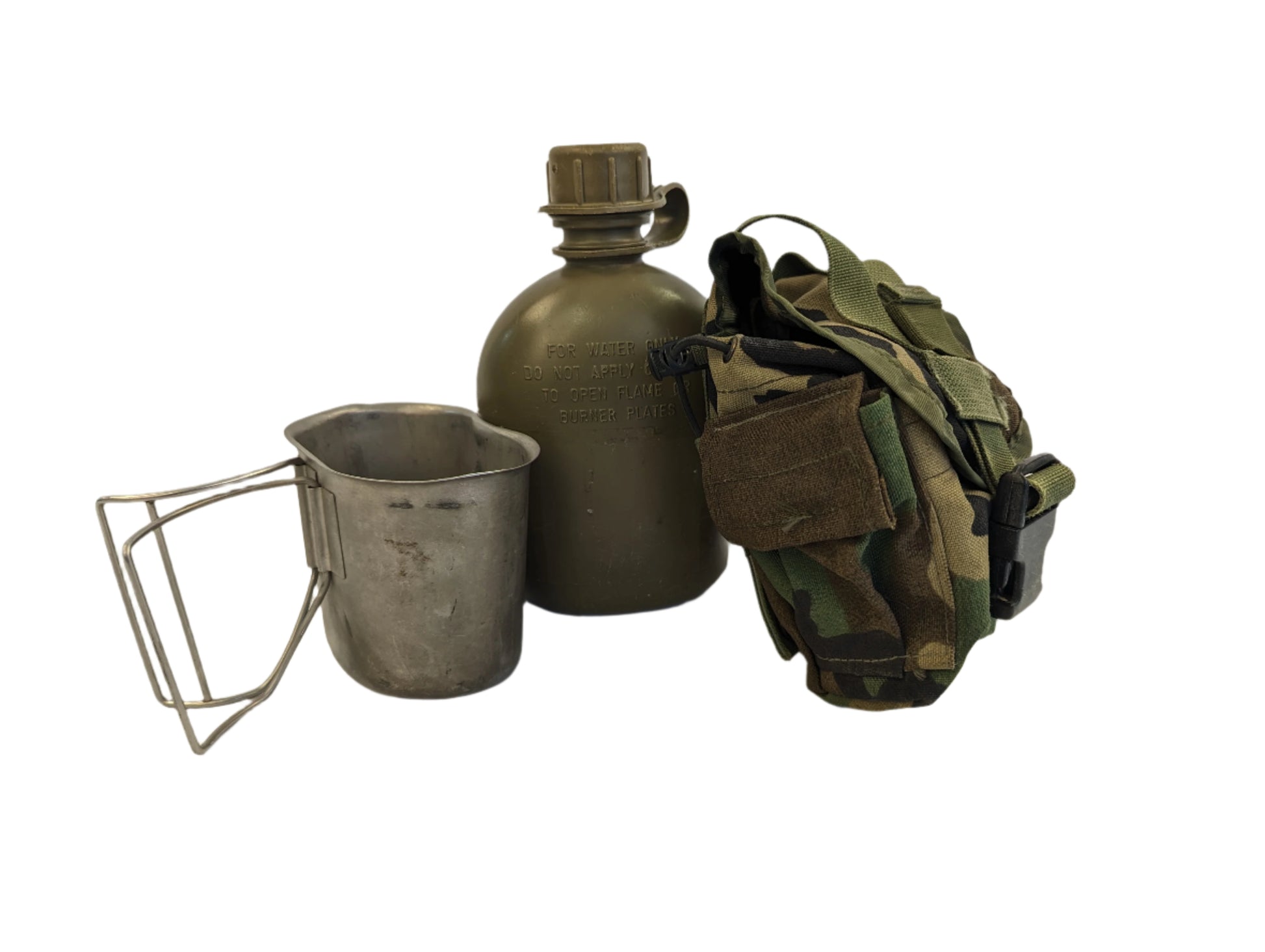 A studio shot of a U.S. Military 1-quart canteen set, featuring an olive green canteen, a metal canteen cup with a wire handle, and a Woodland camouflage fabric pouch, displayed on a white background.