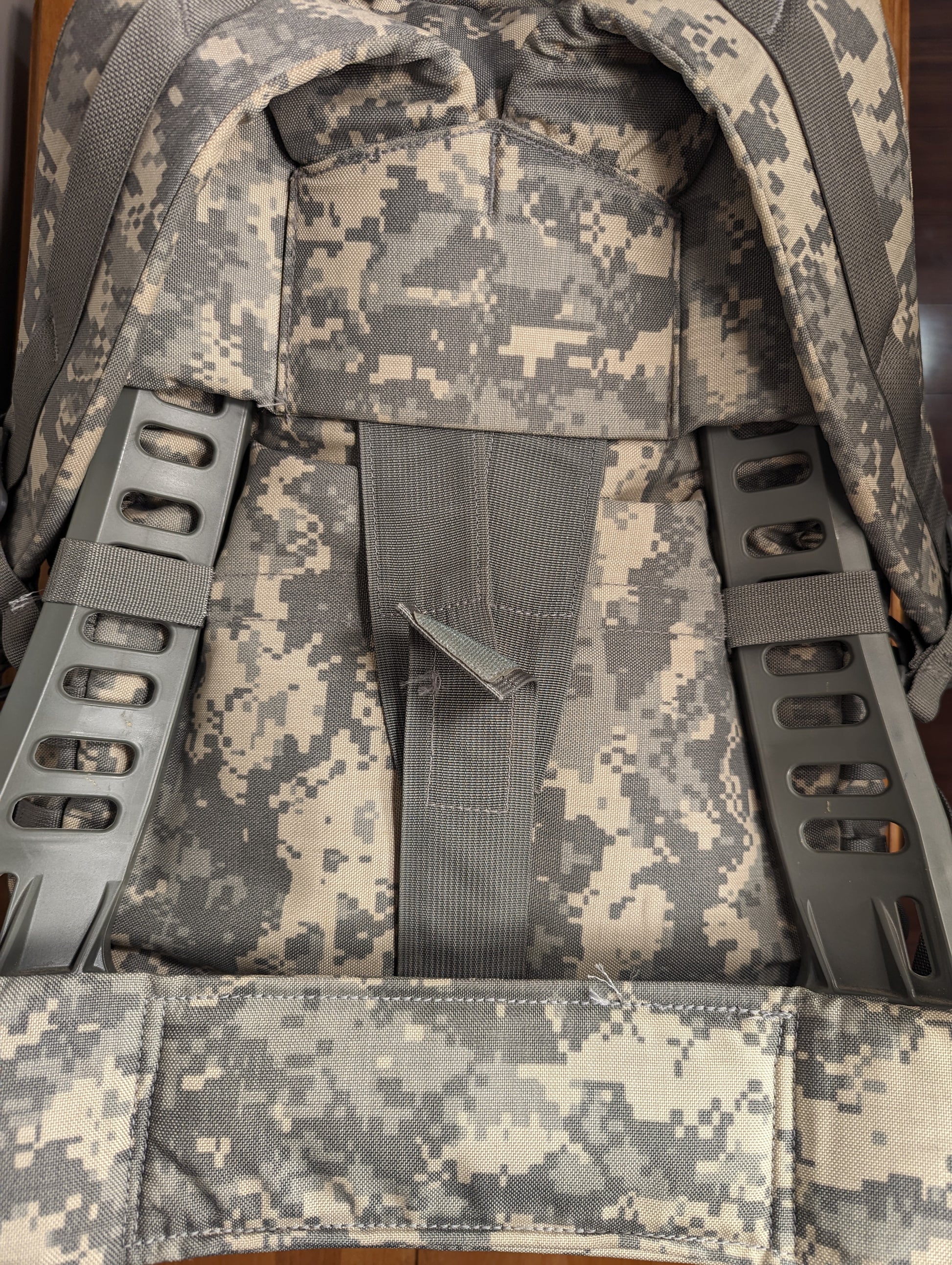 A close-up detail of the padded shoulder harness attachment points on the back of the U.S. Military Medium Field Pack in ACU digital camouflage.
