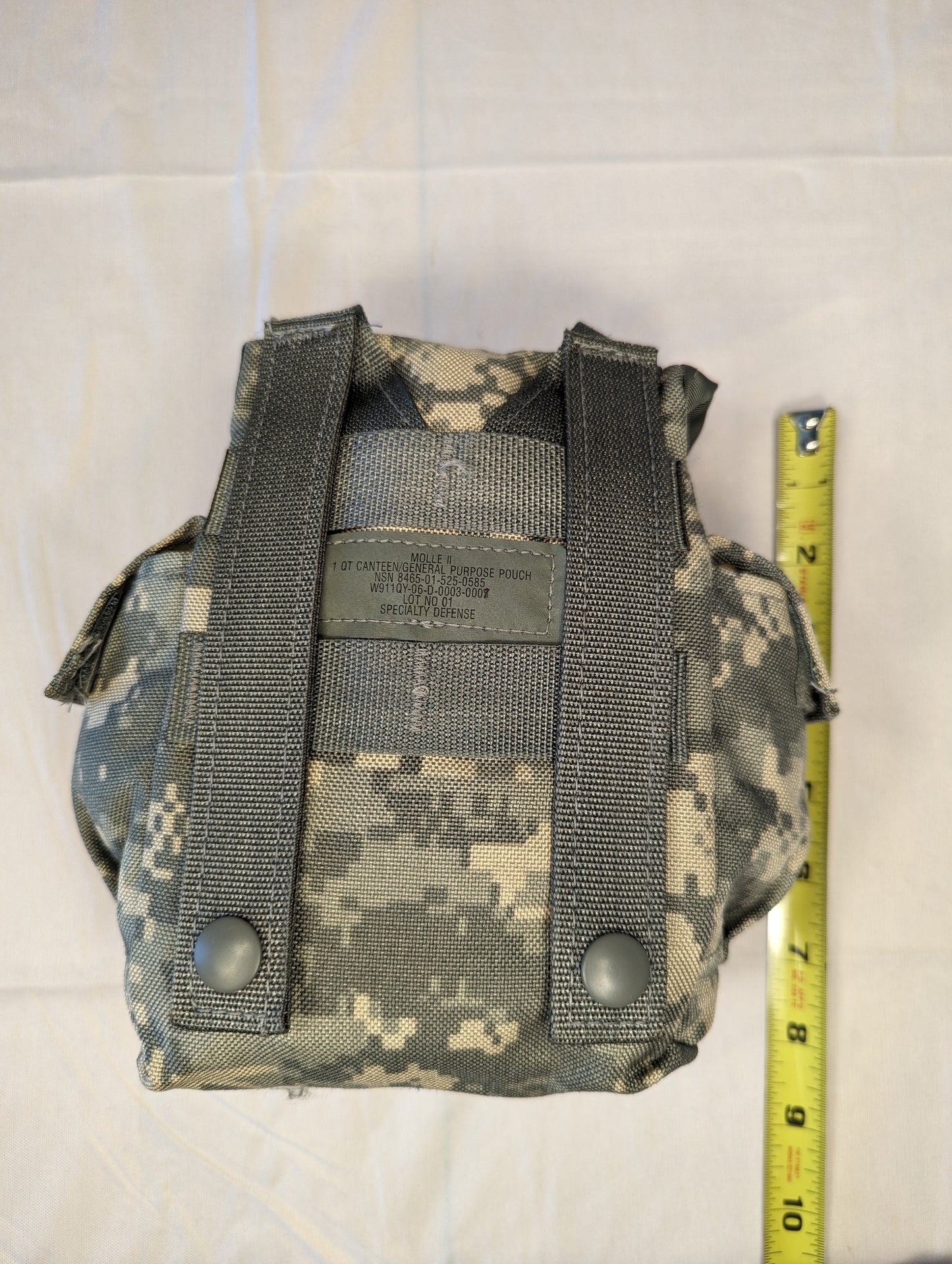 A single U.S. Military Surplus Double Magazine Pouch in ACU camouflage, photographed with a tape measure to indicate its height, and featuring a secure flap closure.