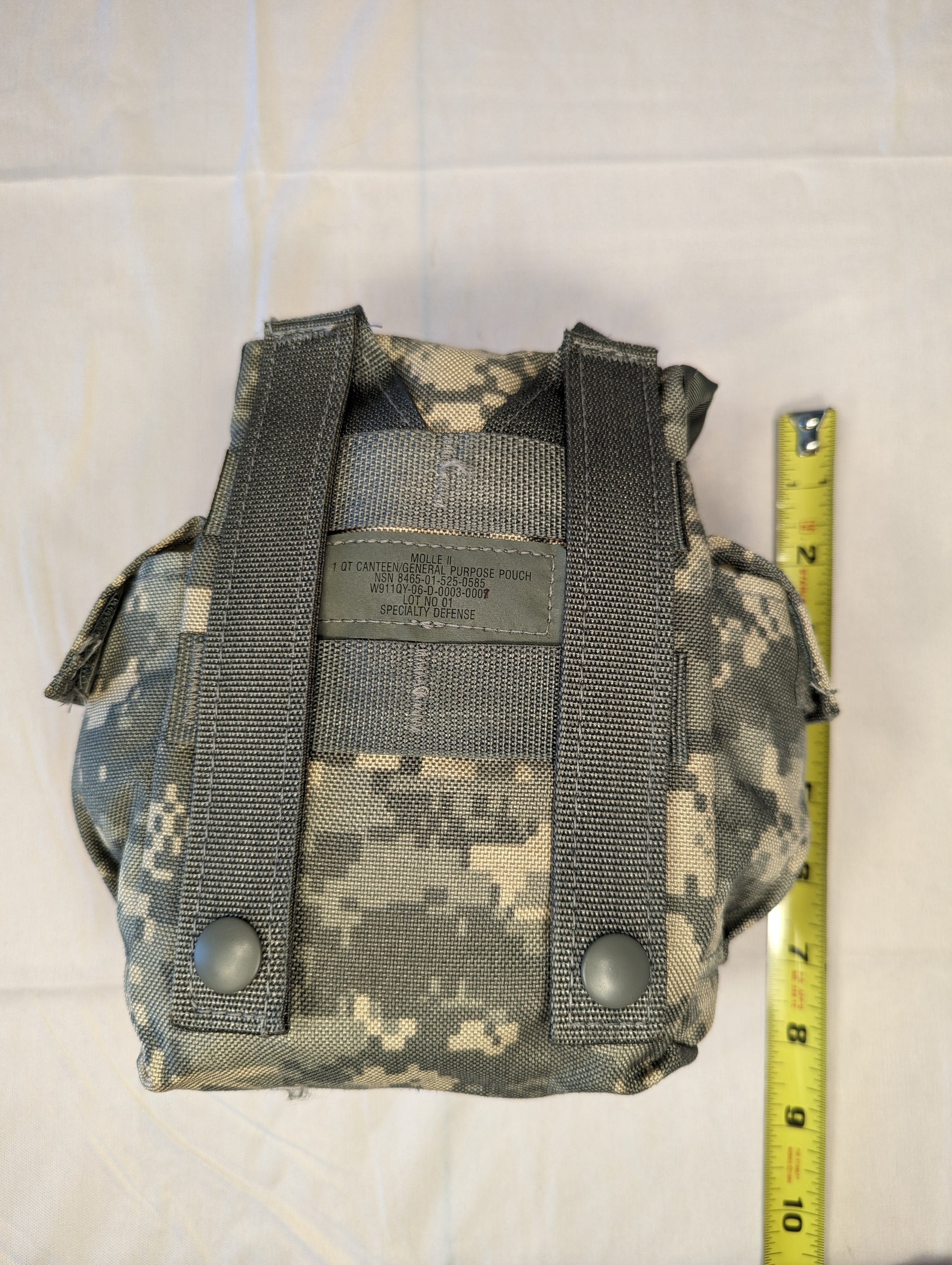 A single U.S. Military Surplus Double Magazine Pouch in ACU camouflage, photographed with a tape measure to indicate its height, and featuring a secure flap closure.