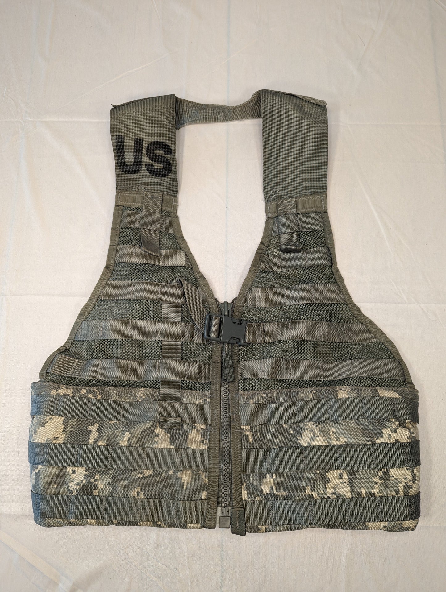 A full front view of a U.S. Military Surplus Load Carrier Vest (FLC) in ACU digital camouflage, unaccessorized, displaying the extensive horizontal MOLLE webbing and the 'U.S.' government marking on the shoulder.